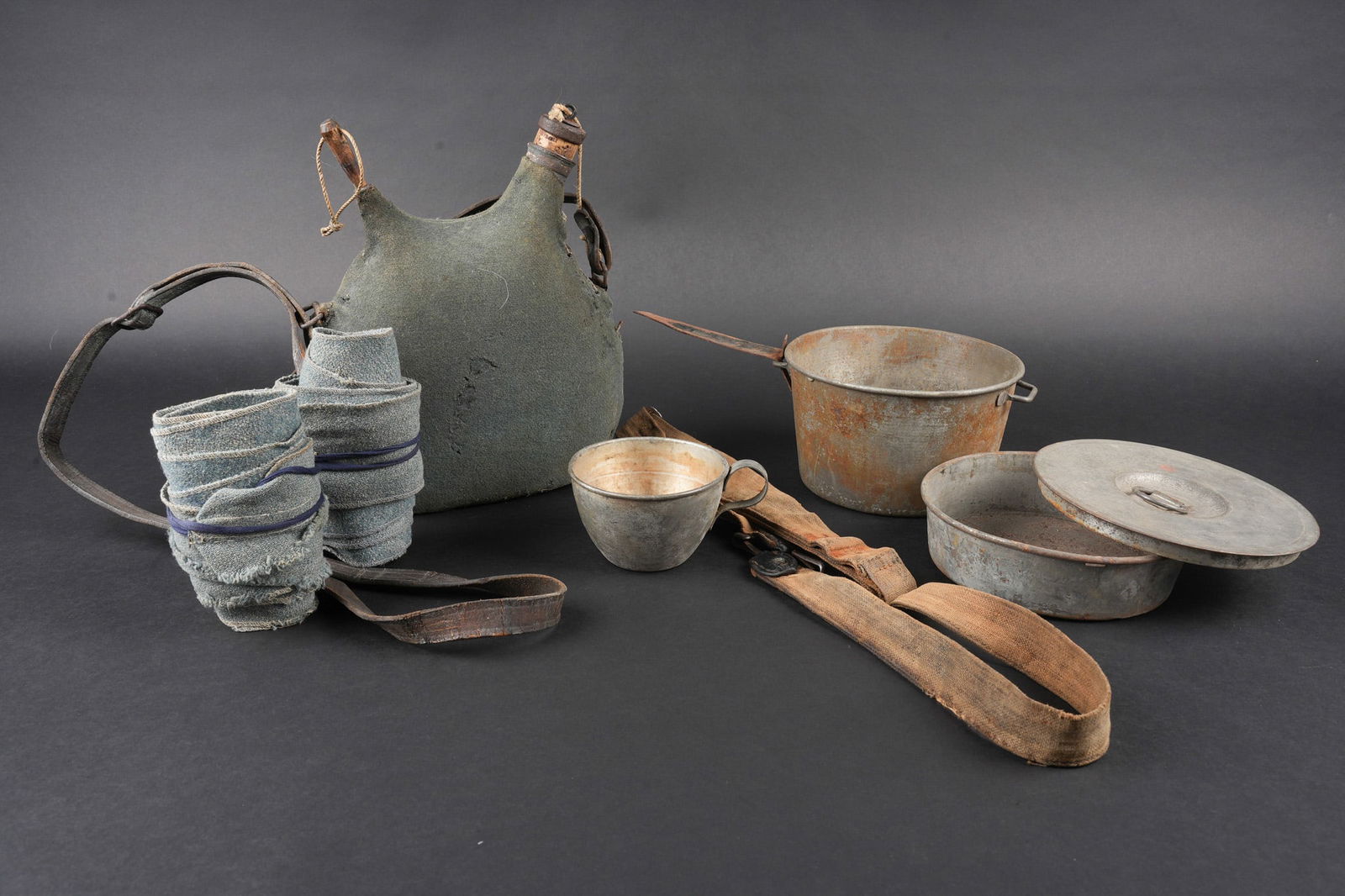 Ensemble d equipements. Equipment set: Ensemble d equipements. Comprenant un bidon 1877 peint en bleu horizon et recouvert d une housse teintee en bleu, un bouchon non conforme, courroie de transport d origine. Une gamelle modele 1852 en f