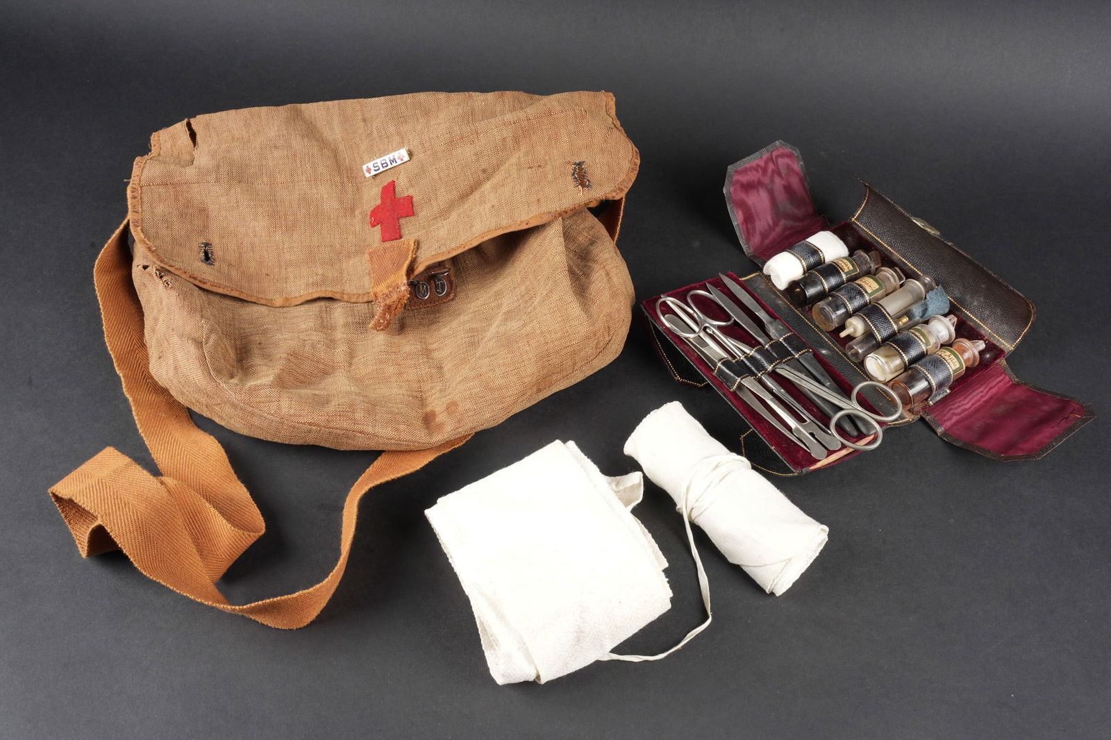 Musette d infirmiere 1892. Nurse’s haversack, Model 1892: Musette d infirmiere 1892. Musette en forte toile cachou portant sur le rabat une croix rouge en feutrine ainsi que l insigne emaille SBM. Au niveau de la partie en toile retenant l ardillon, l