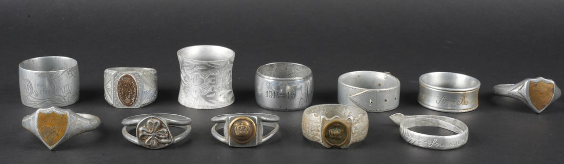 Lot artisanat de tranchees. Lot of trench art: Lot artisanat de tranchees. Comprenant douze ronds de serviette, un souvenir de Verdun 1917, un Rene 1916, un en forme de bague ajouree avec un bouton prussien, un en forme de bague avec un bouton