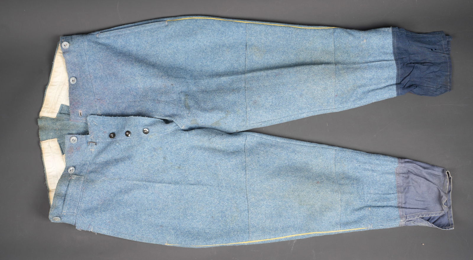 Pantalon culotte 1914. Breeches, Model 1914: Pantalon culotte 1914. Entierement confectionne en drap bleu horizon, passepoil jaune de l infanterie, martingale au dos presente. Manchettes en coton bleu, pantalon se fermant par six boutons a