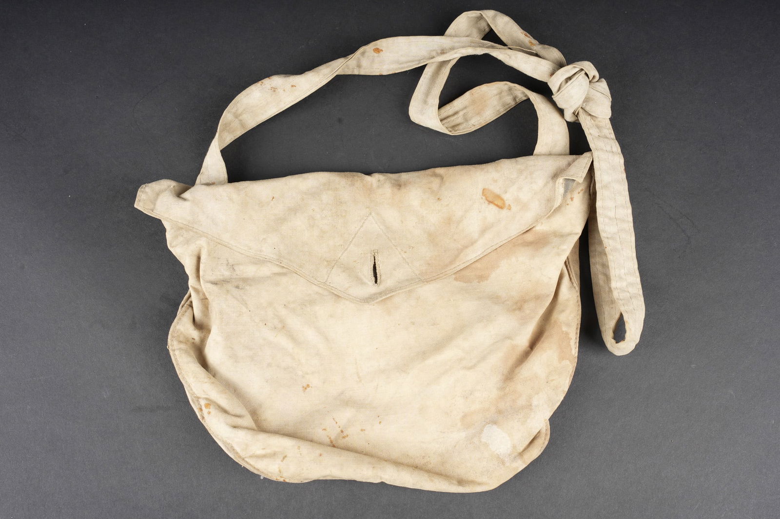 Pochette de transport masque anti gaz M2. M2 gas mask carrying pouch: Pochette de transport masque anti gaz M2. En toile ecrue, petit compartiment pour oculaires de rechange, sangle d origine. Pas d accroc majeur mais quelques taches. M2 gas mask carrying satchel. Ecru