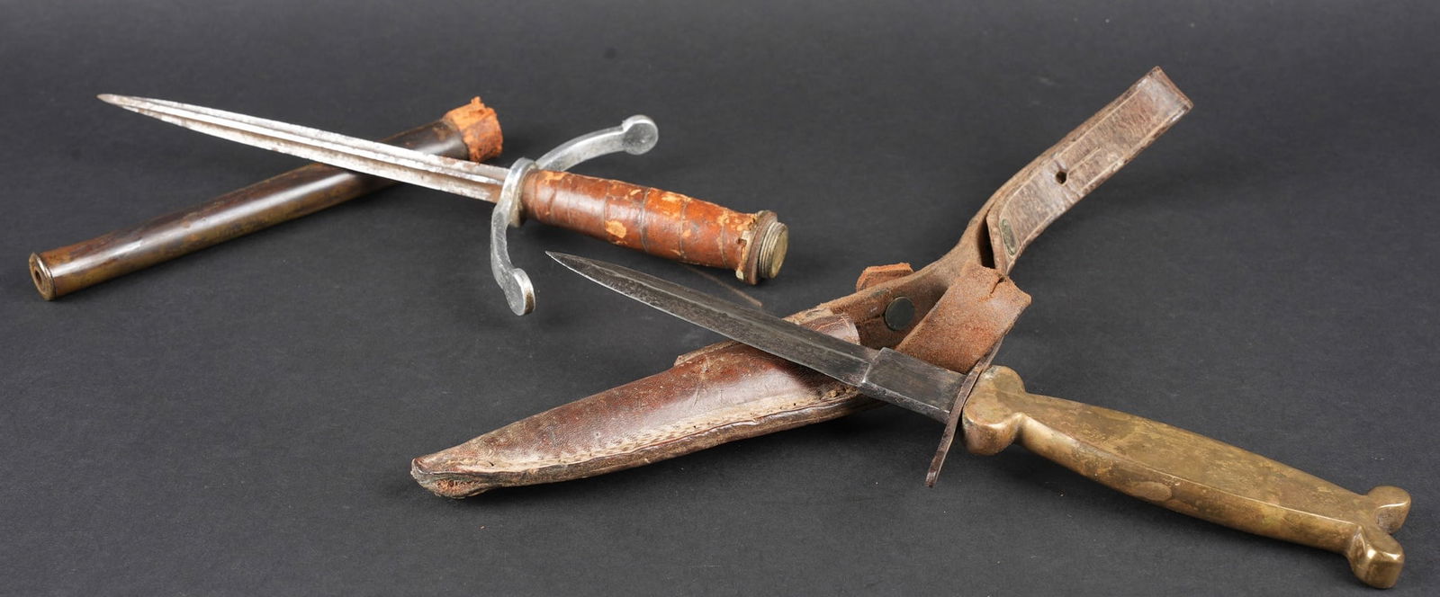 Lot de poignards artisanaux. Lot of handmade fighting daggers: Lot de poignards artisanaux. Comprenant un poignard confectionne a partir d une lame de Vengeur ne mesurant plus que 13,5cm, poignee en laiton moule, garde metallique. Fourreau en cuir rivete est copi