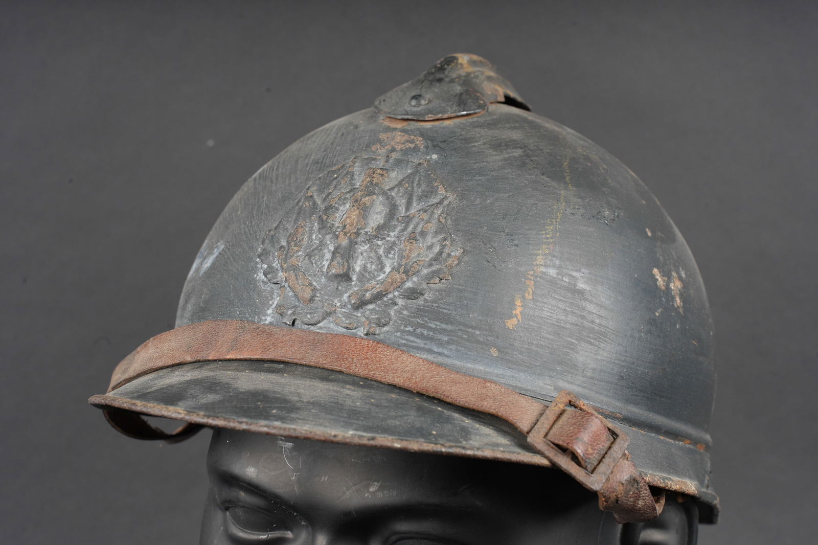 Casque Adrian 1915 Intendance. Adrian helmet, Model 1915, Intendance (Supply Service): Casque Adrian 1915 Intendance. Casque modele 1915 en peinture bleu horizon d usine recouverte d une peinture plus foncee appliquee au pinceau. Attribut frontal de l intendance, modele non ajoure porta
