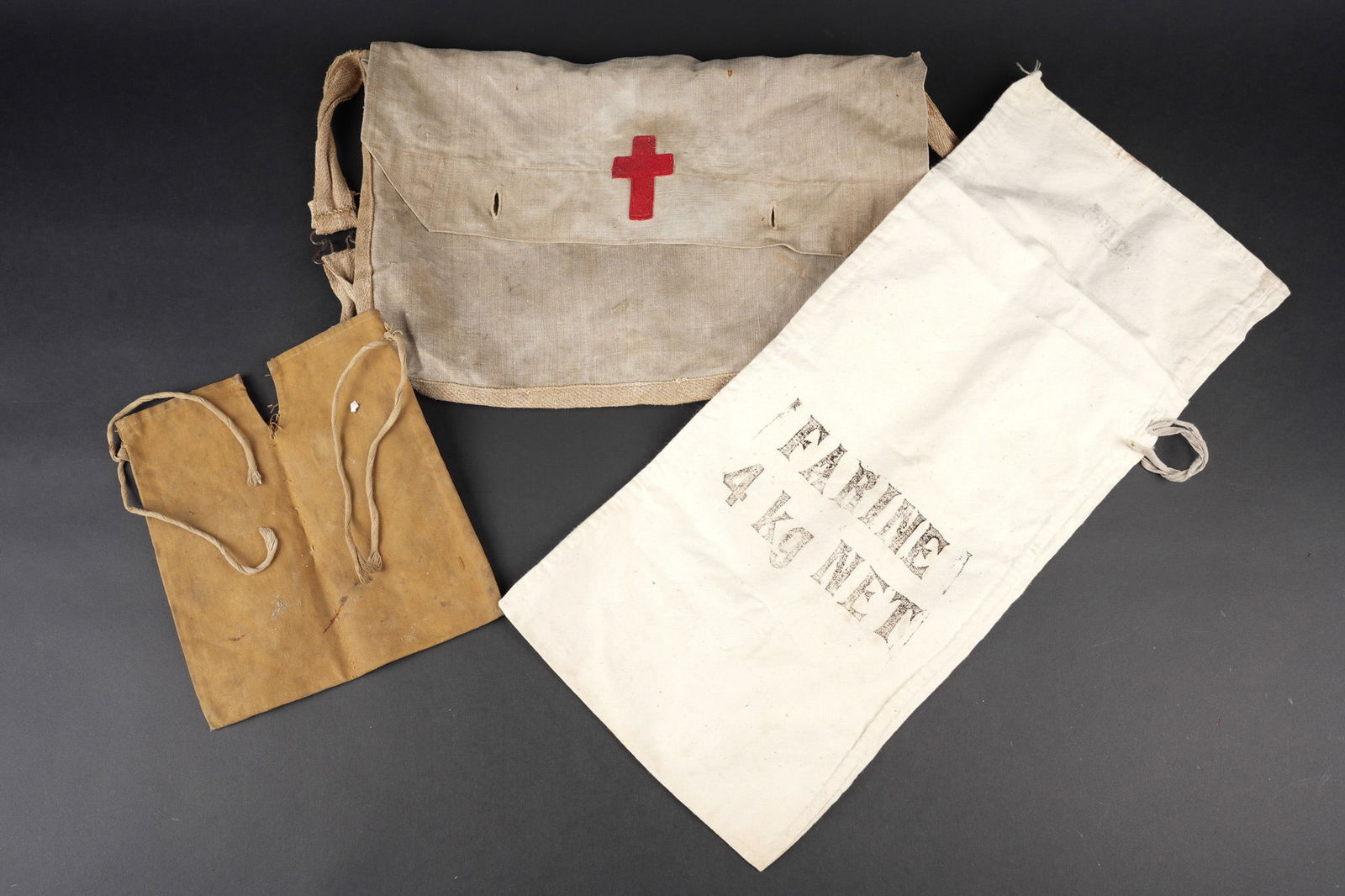 Musette et petits equipements. Haversack with small equipment items: Musette et petits equipements. Comprenant une musette 1892 sur laquelle est cousue posterieurement une croix catholique realisee en drap garance, traces de tampon de reception. Un sac a farine vide de