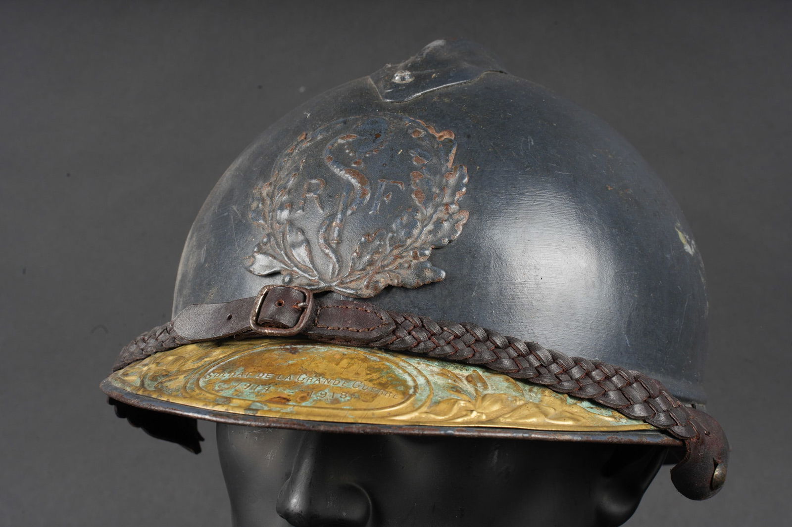 Casque Adrian 1915 service de sante. Adrian helmet, Model 1915, Medical Service: Casque Adrian 1915 service de sante. Casque modele 1915, peinture d usine recouverte d une seconde couche plus sombre appliquee au pinceau. Attribut modele 1915 du service de sante, jugulaire en cuir