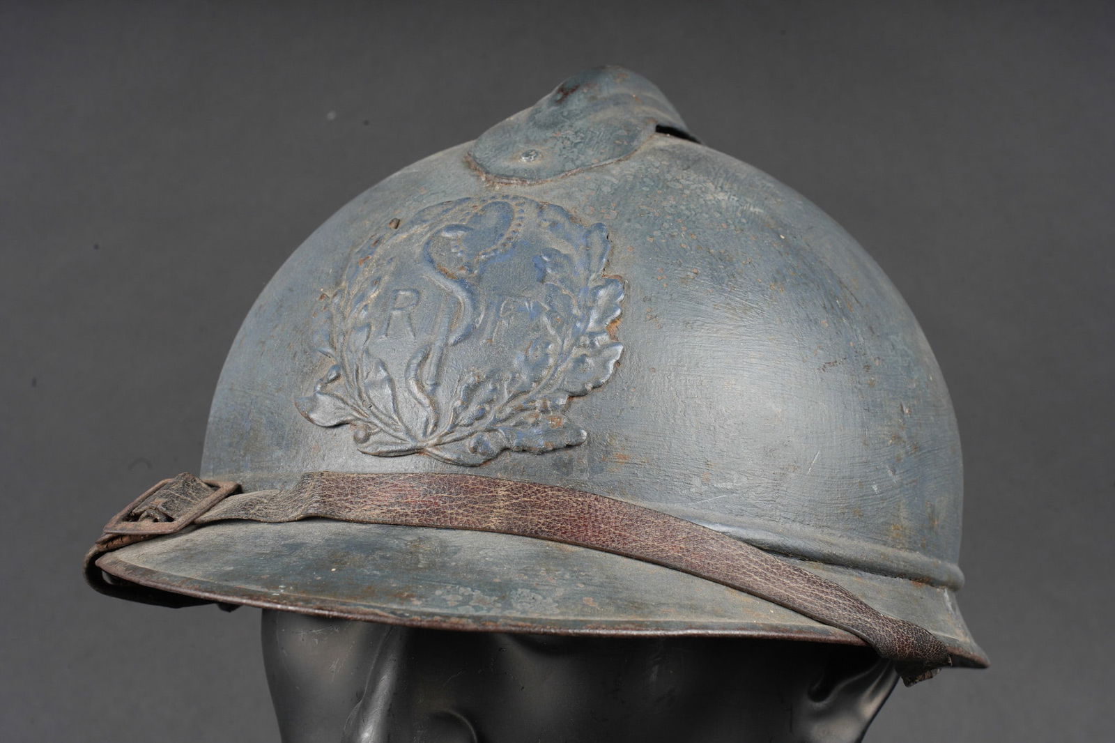Casque Adrian 1915 service de sante. Adrian helmet, Model 1915, Medical Service: Casque Adrian 1915 service de sante. Casque modele 1915, peinture d usine recouverte d une seconde couche plus sombre appliquee au pinceau. Attribut modele 1915 du service de sante. Coiffe du premier