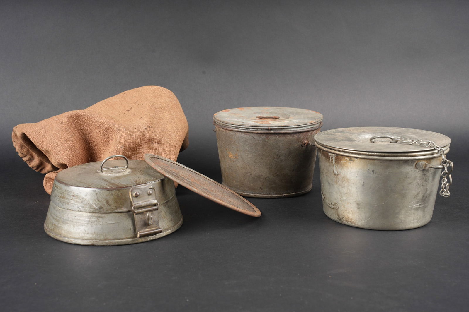 Housse de transport pour gamelles. Mess-tin transport cover: Housse de transport pour gamelles. Housse en toile cachou se fermant par un lacet contenant deux gamelles en fer etame avec leur plat, une avec chainette posterieure et l autre absente. Un tamis filtr