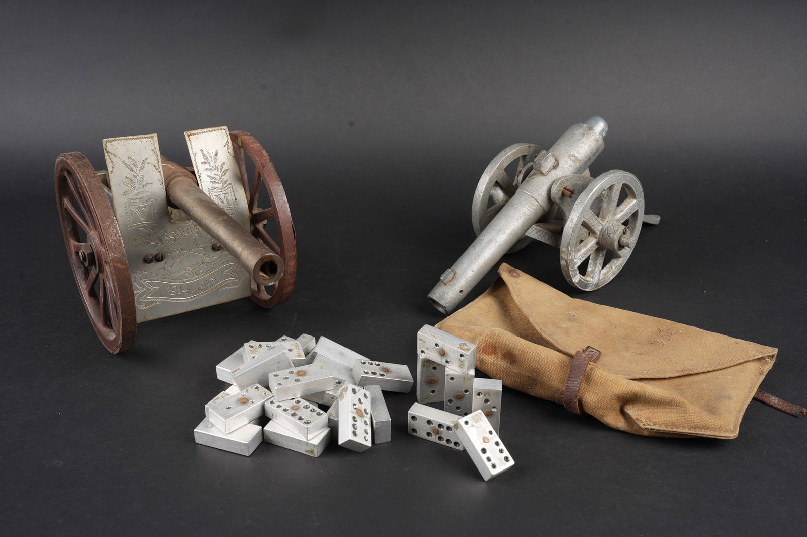 Lot artisanat de tranchees. Lot of trench art: Lot artisanat de tranchees. Comprenant deux repliques de canon dont un realise en aluminium et en metal, arme d un ressort permettant de tirer de petits projectiles. Plaque de blindage entierement gra