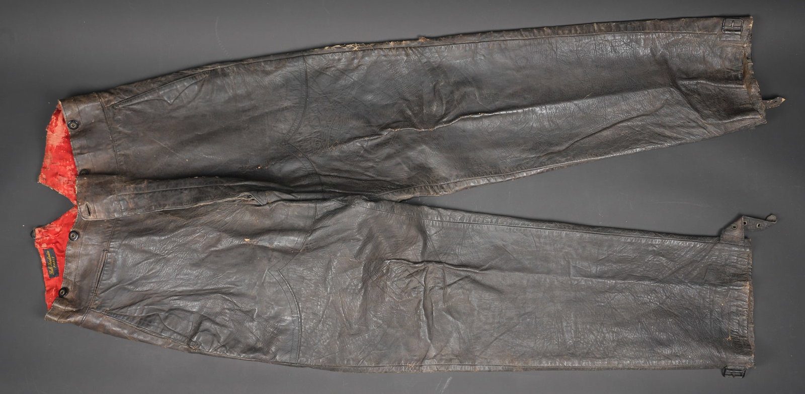 Pantalon de vol. Flight trousers: Pantalon de vol. En cuir marron, doublure en rayonne portant l etiquette La belle jardiniere a Paris. Le bas des jambes se regle a l aide d une patte de serrage a boucle, la majeure partie des boutons