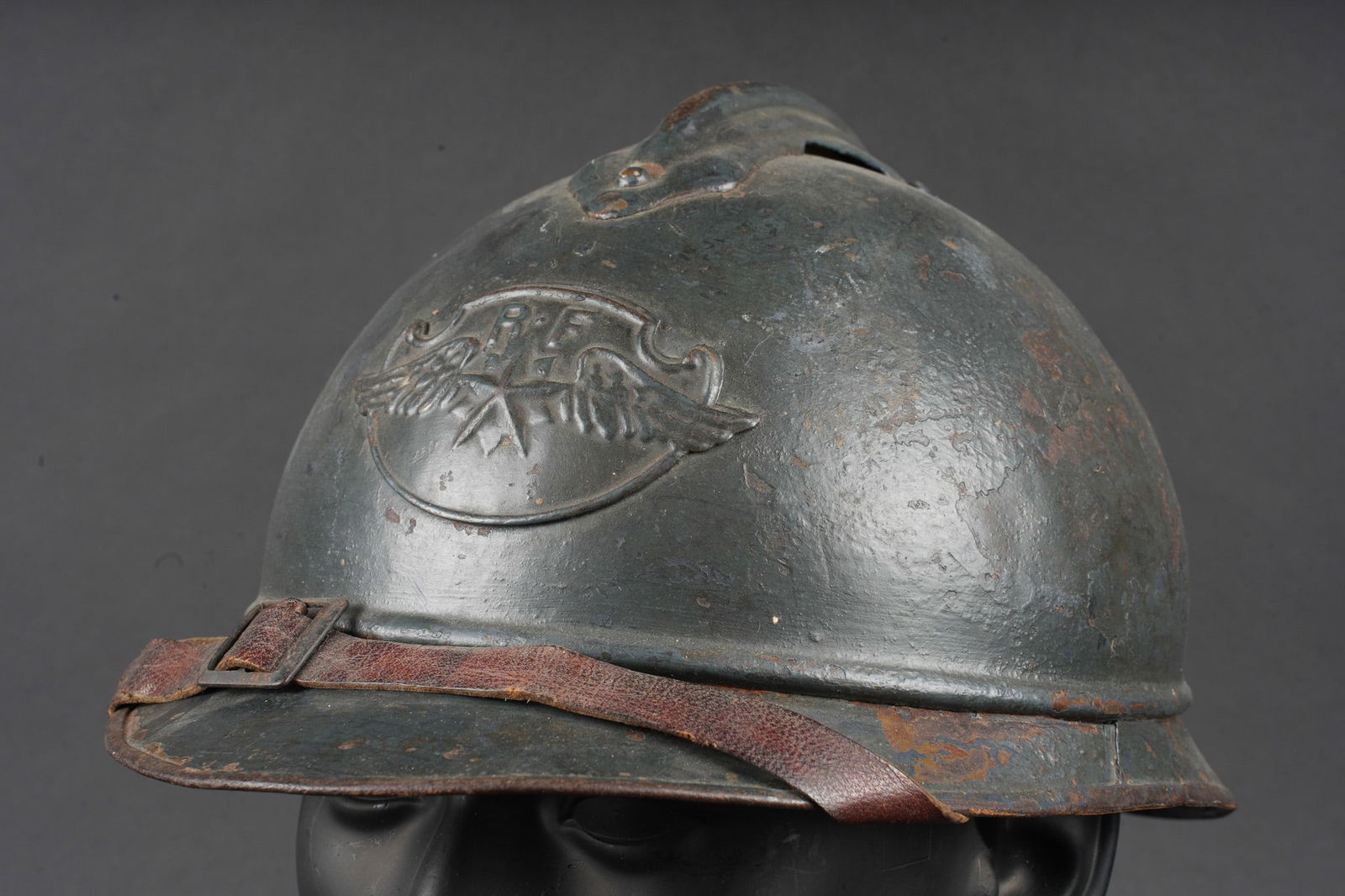 Casque Adrian 1915 aviation. Adrian helmet model 1915 aviation: Casque Adrian 1915 aviation. Casque modele 1915 en peinture bleu horizon d usine recouverte d une peinture plus foncee, portant l attribut modele 1923 de l aviation. Coiffe du premier type, bandeau en