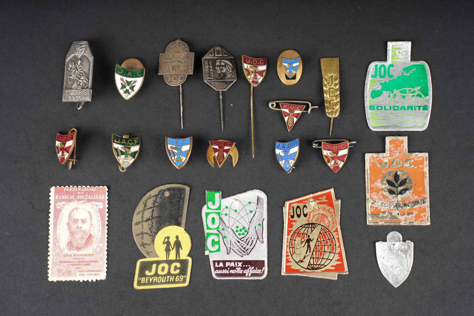Ensemble d insignes JOC et divers. Group of JOC badges and miscellaneous items: Ensemble d insignes JOC et divers. Ensemble comprenant 3 variantes d insigne des JOC, 2 variantes d insigne des LOC, un insigne de boutonniere et un insigne des JEC, un insigne des JACF, un insigne de