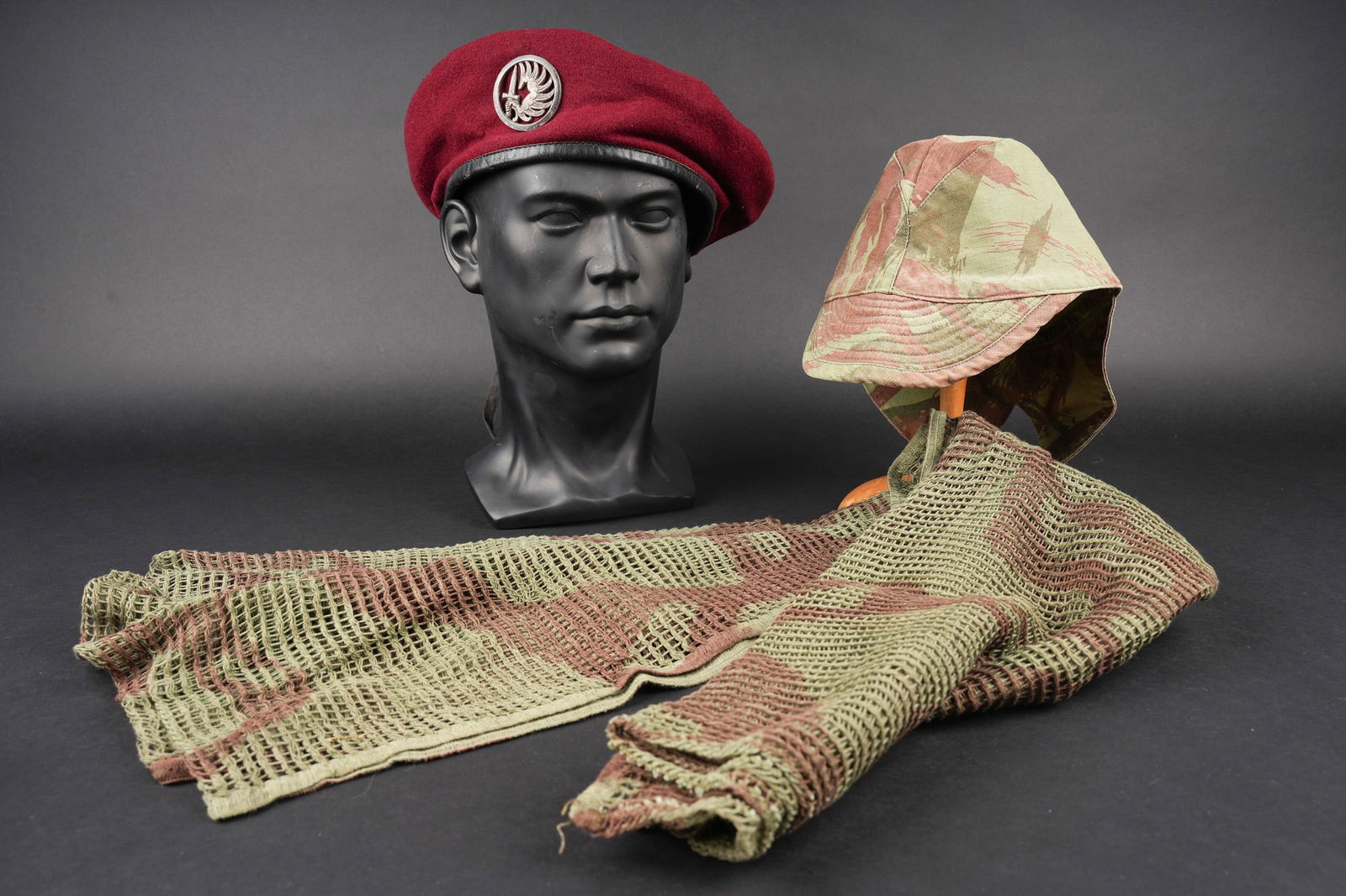 Ensemble de coiffures parachutistes. Set of paratrooper headdress: Ensemble de coiffures parachutistes. Comprenant un beret commando modele 1946 realise en trois parties en laine amarante. Deux œillets en peinture d origine. Doublure en coton noir surpique en losang