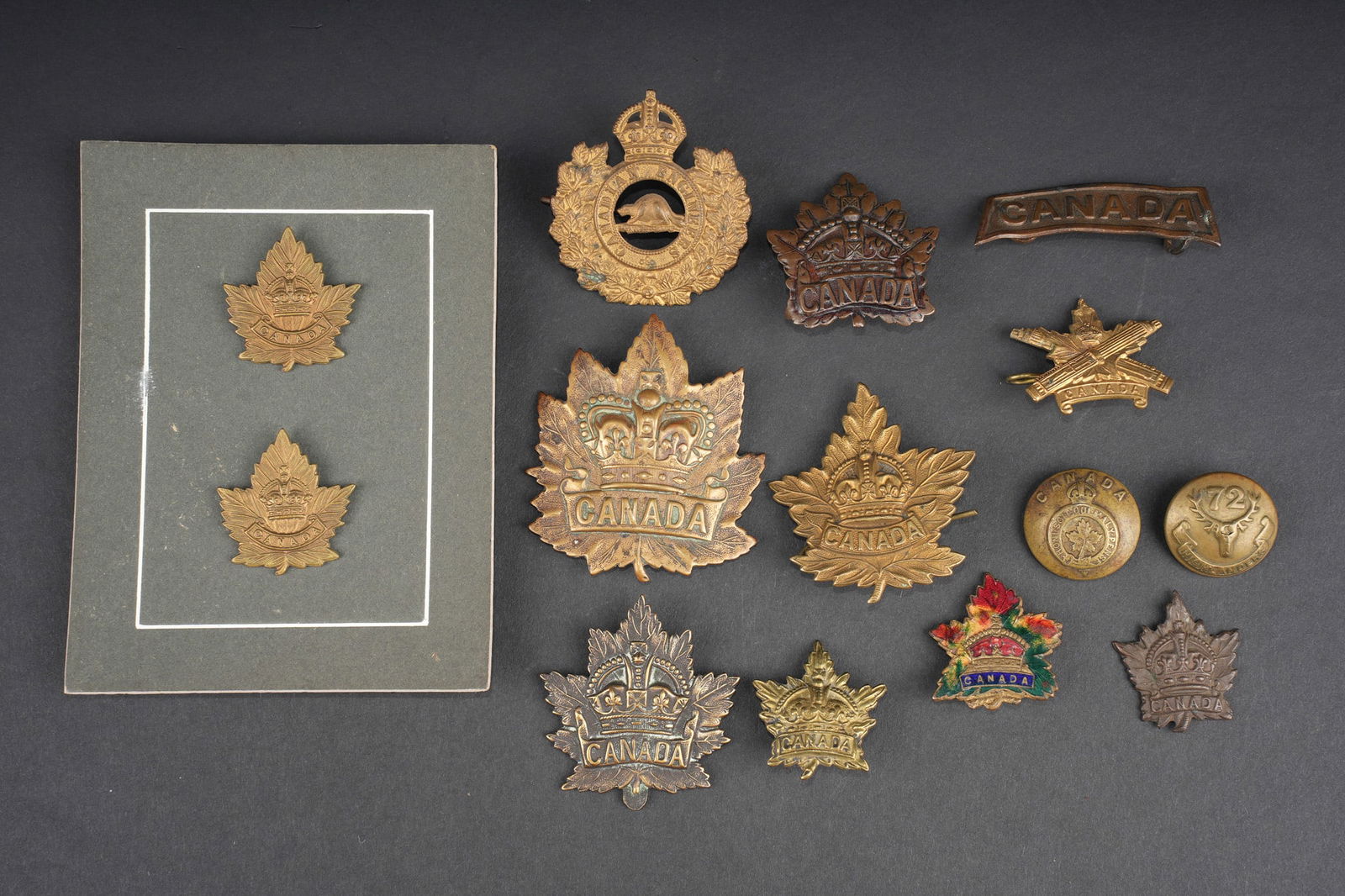 Insignes canadiens ww1. WWI Canadian insignia.: Lot d insignes canadiens ww1. Cap badges, collar badges, title, broche et boutons. 14 pieces. Usure d usage, patine, certains avec attaches manquantes. Lot of Canadian WWI insignia including cap