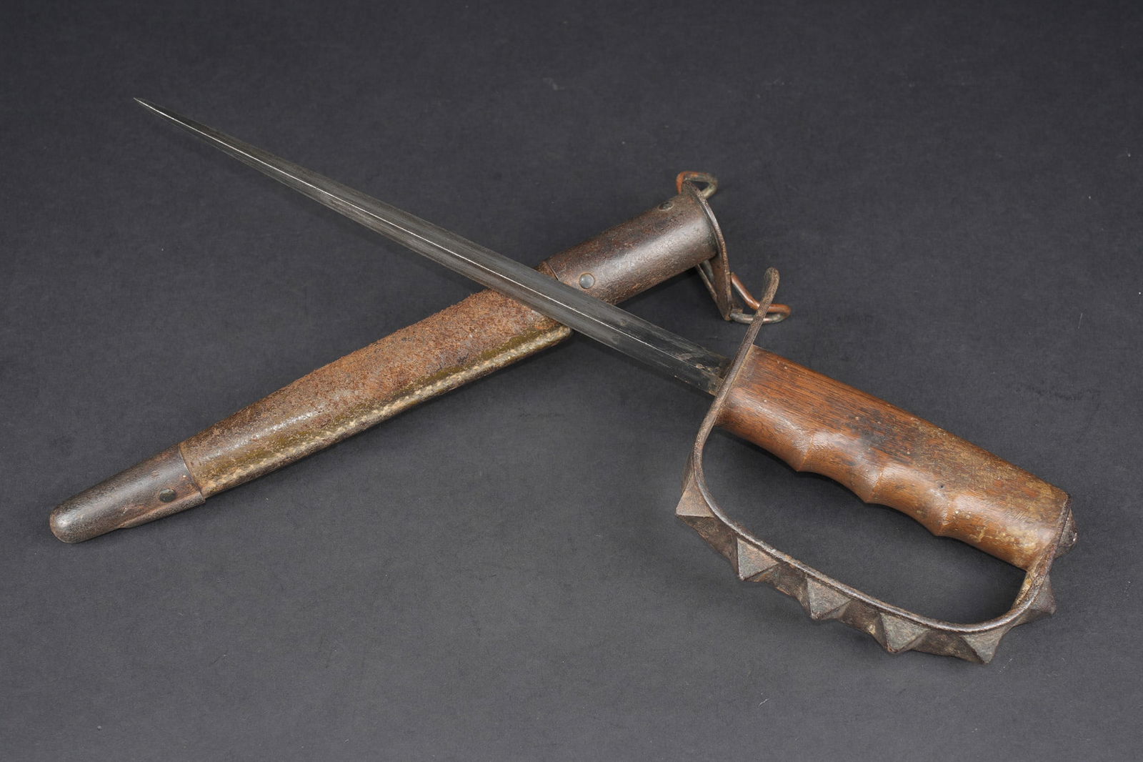 Trench Knife US17. US Army Trench Knife: Poignard de combat Trench Knife US17. Poignee en bois, marquage sur le dessous du quillon LF & C 1917, belle lame triangulaire. Garde garnie de pics pyramidaux. Fourreau en cuir et garnitures en metal