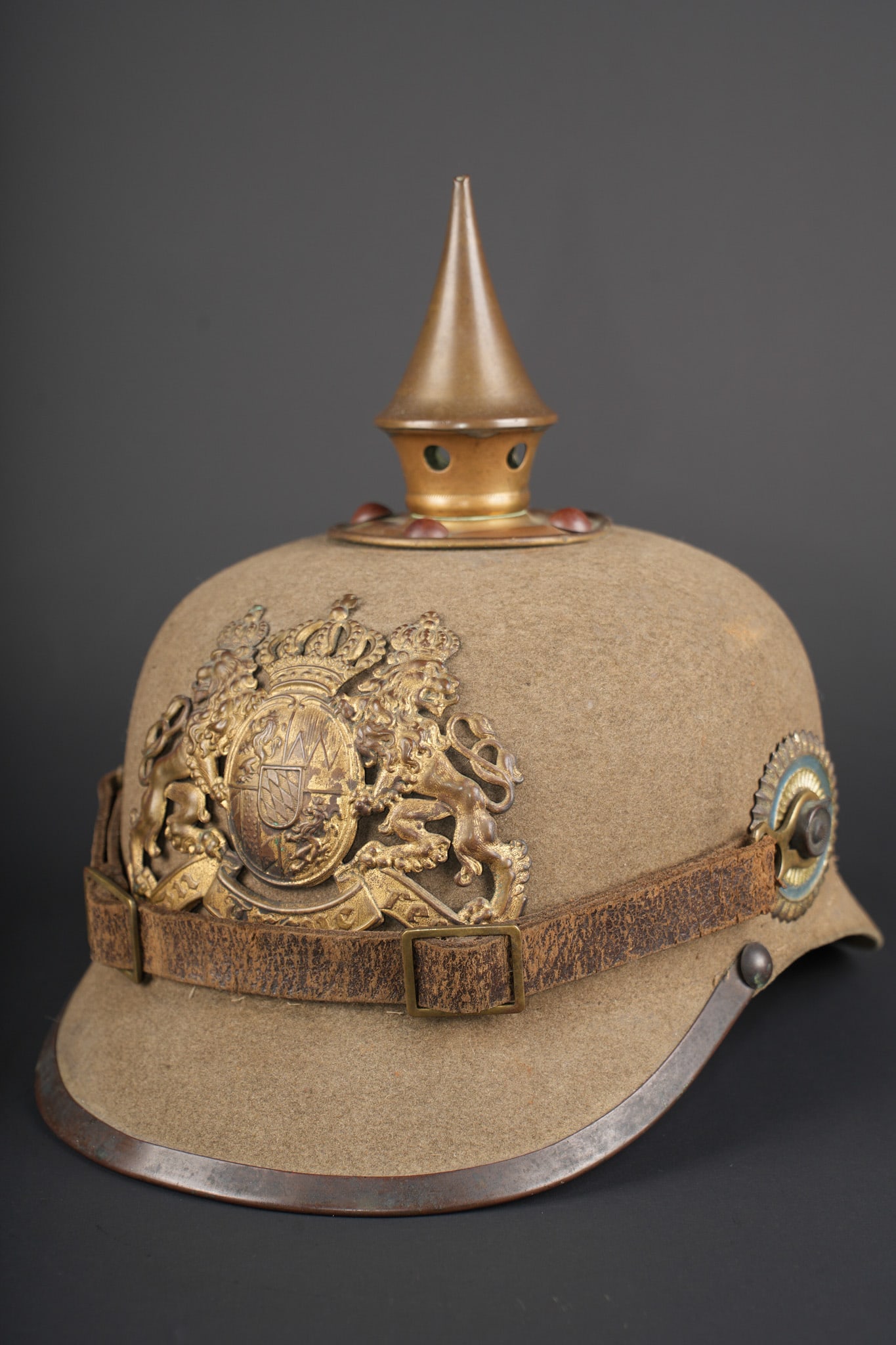 Casque a pointe ersatz en feutre bavarois. Bavarian felt ersatz pickelhaube: Casque a pointe ersatz en feutre bavarois. Belle bombe en feutre feldgrau, rigide, avec jonc de visiere. Toutes garnitures laiton M1895. Plaque bavaroise M1896 avec jolie patine, pontets soudes d orig