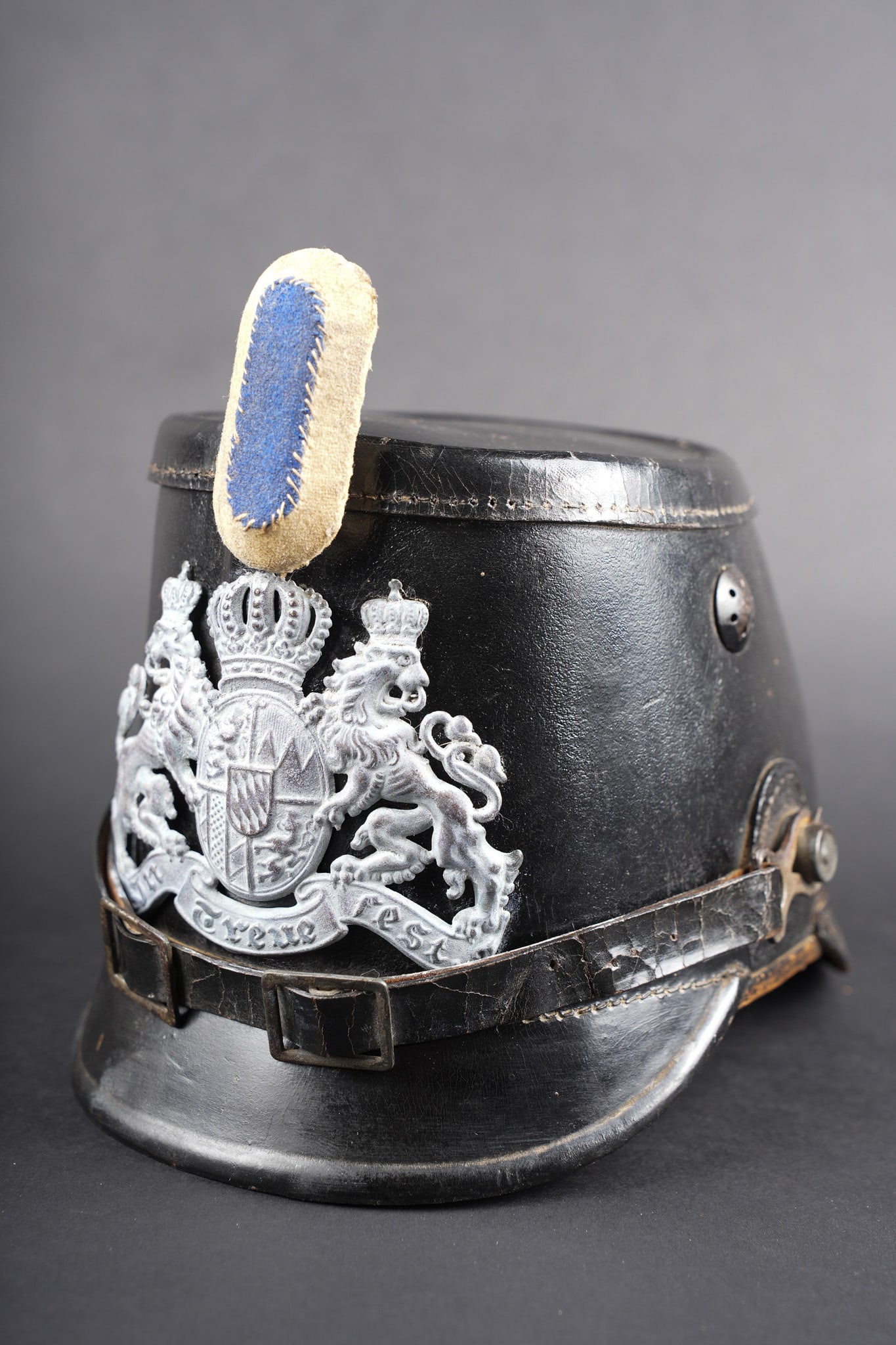 Tschako bavarois M1915. Bavarian M1915 tschako: Tschako bavarois M1915. Belle bombe, non repercee, de forme specifique bavaroise. Bel aspect, marquage fabricant a l interieur sur la calotte. Belle plaque bavaroise en fer peint feldgrau, fixee par