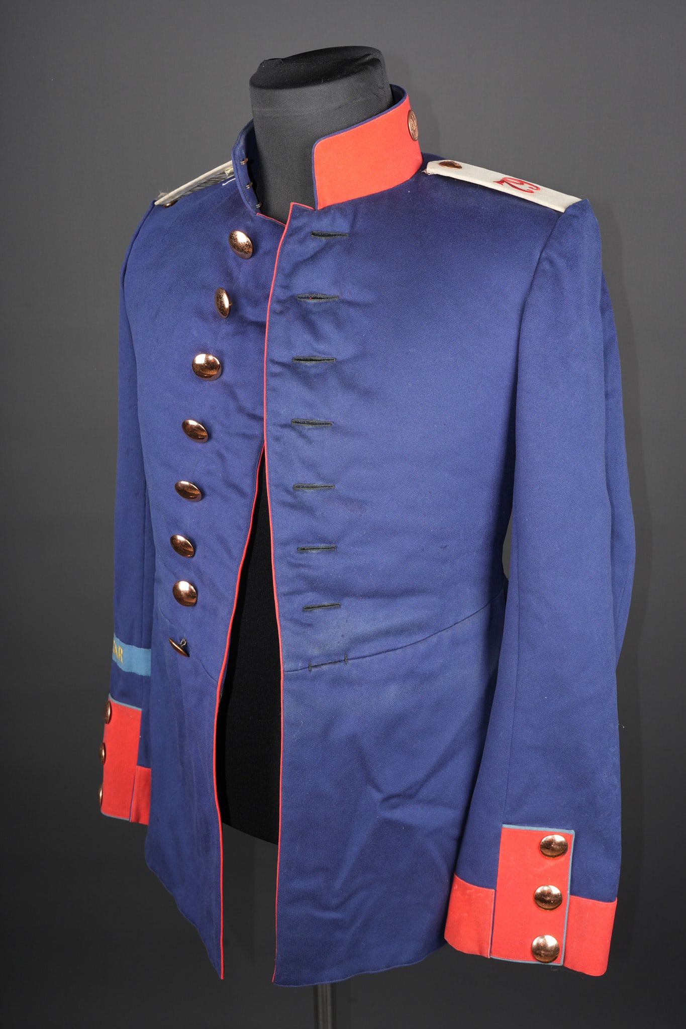 Tunique du JR79 de Hanovre bande de bras Gibraltar. Tunic of Hanoverian Infantry Regiment 79 (JR 79): Tunique du JR79 de Hanovre bande de bras Gibraltar. Tunique coloree d avant guerre en drap bleu, passepoil rouge. Col droit fermant par 3 crochets, double de rouge sur l exterieur. Parements de