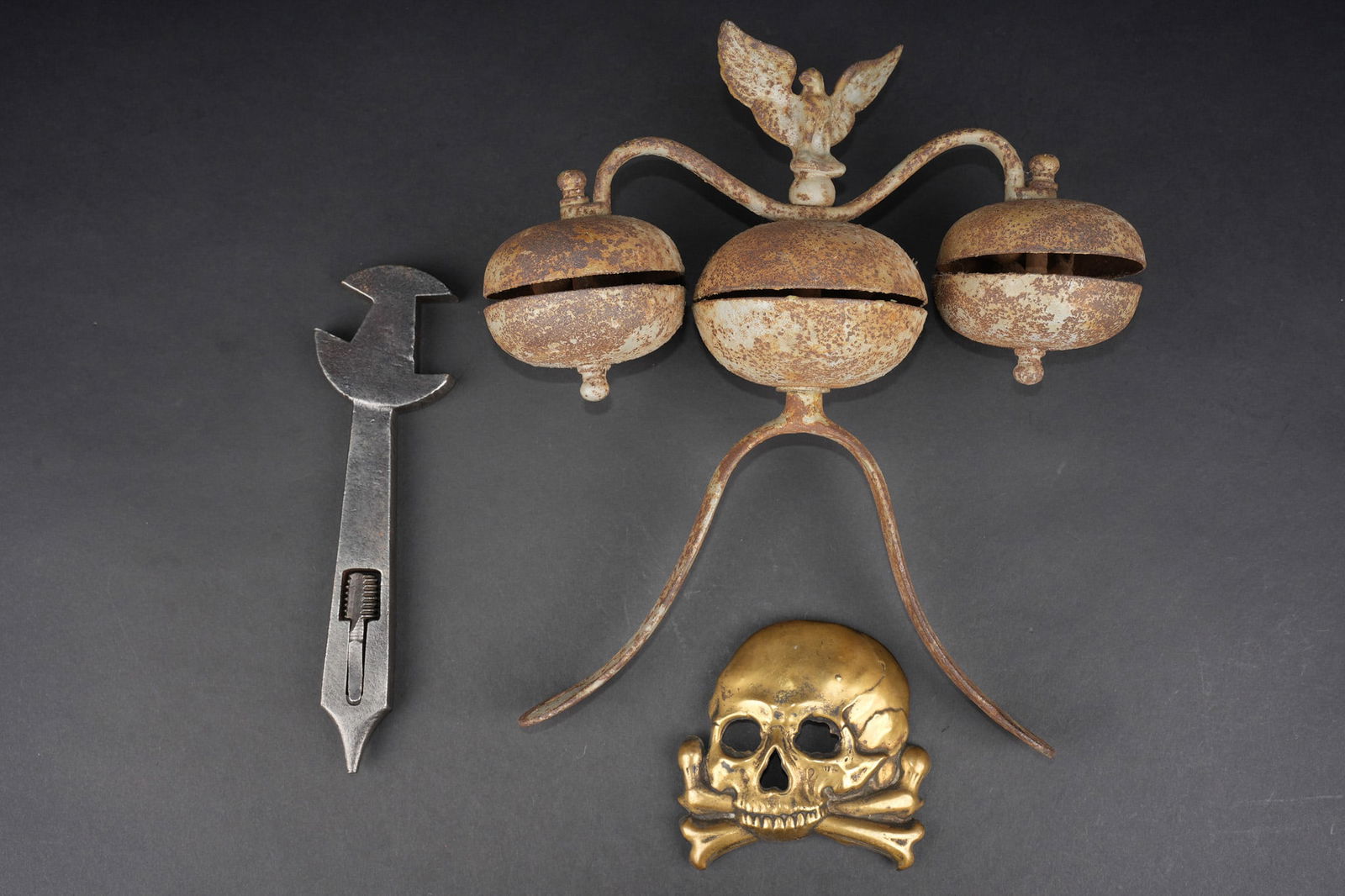 Lot Cavalerie allemande. Lot of German cavalry items: Lot Cavalerie allemande. Une plaque de Colback de Hussard, tete de mort en laiton avec attaches a pattes repliables, authenticite non garantie. Une cle a crampons pour fers a chevaux. Un trio de cloch