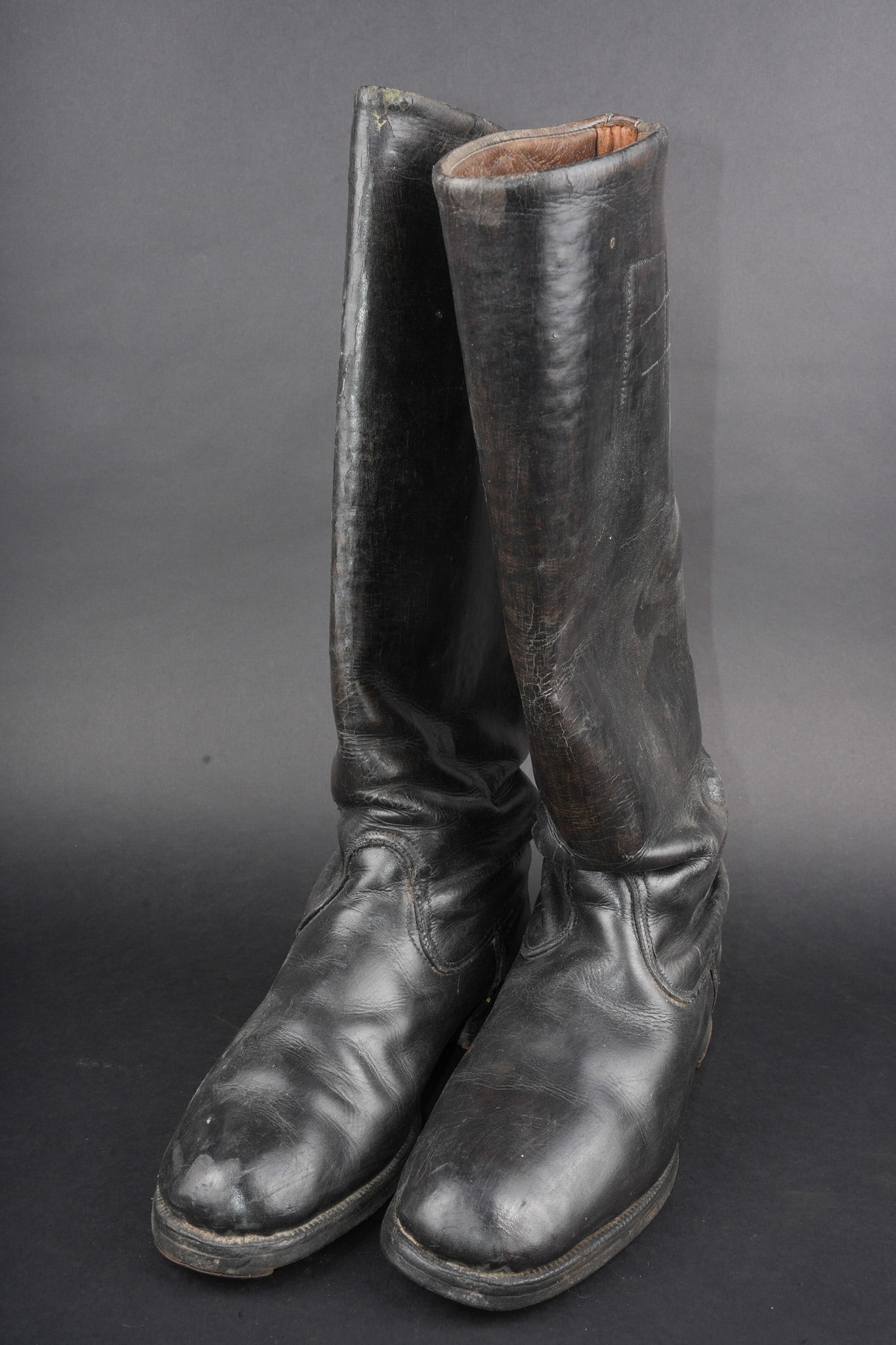 Paire de bottes d officier allemand. Pair of German officer boots: Paire de bottes d officier allemand. En cuir cire noir, tige haute, couture de renfort sur le coup de pied. Tirettes en tissu tricolore aux couleurs de l Empire. Talon avec fer en U. Pas de marquage v