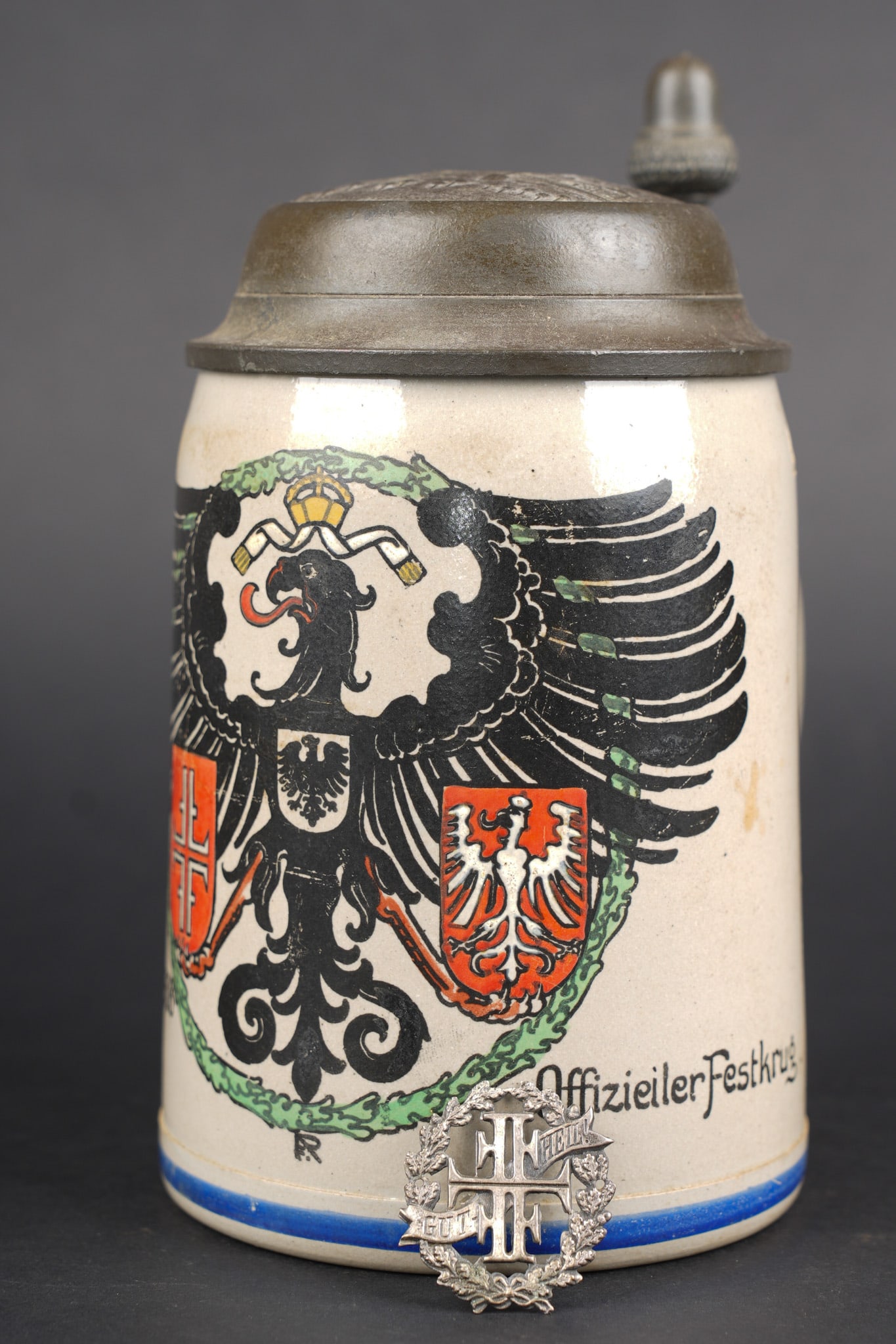 Chope en gres Turnfest Frankfurt am Main 1908 et insigne. Stoneware stein from the Turnfest: Chope en gres Turnfest Frankfurt am Main 1908 et insigne. Chope en gres marquee Offizier-Festkrug a l occasion de la XI Turnfest de 1908 a Frankfurt am Main, bel etat. On joint un insigne du Turnerbun