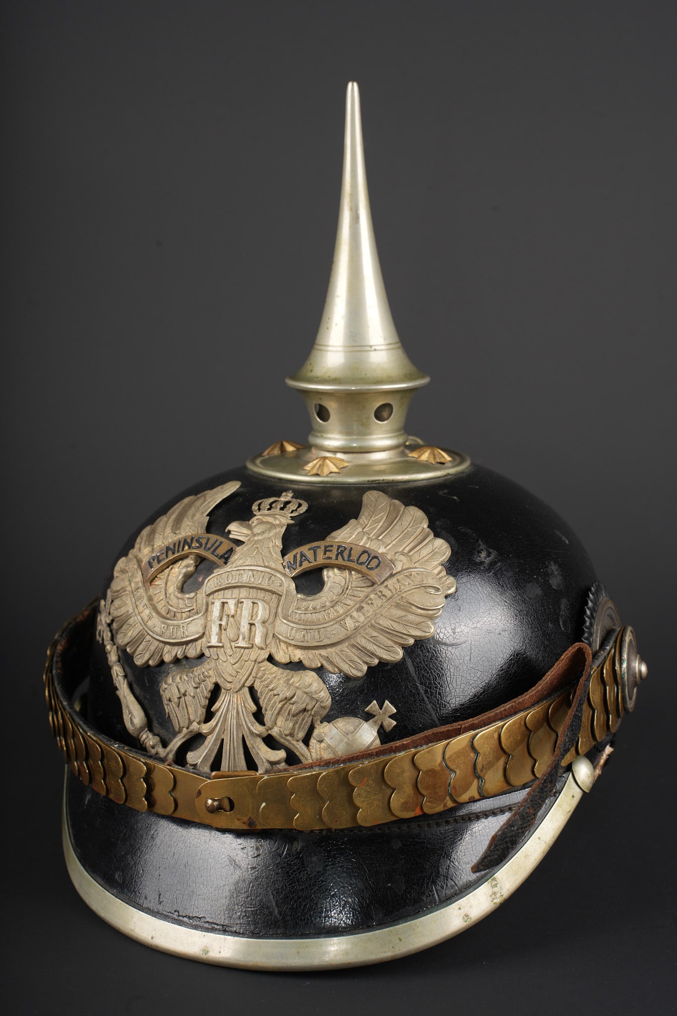 Casque du bataillon de Pionniers prussien n°10 - modele 1871-99 d’officier. Officer’s helmet of: Casque du bataillon de Pionniers prussien n°10 - modele 1871-99 d’officier. Tres beau casque avec la bombe, la visiere et la nuquiere ayant conserve un revetement sans accident, ce qui lui donne un