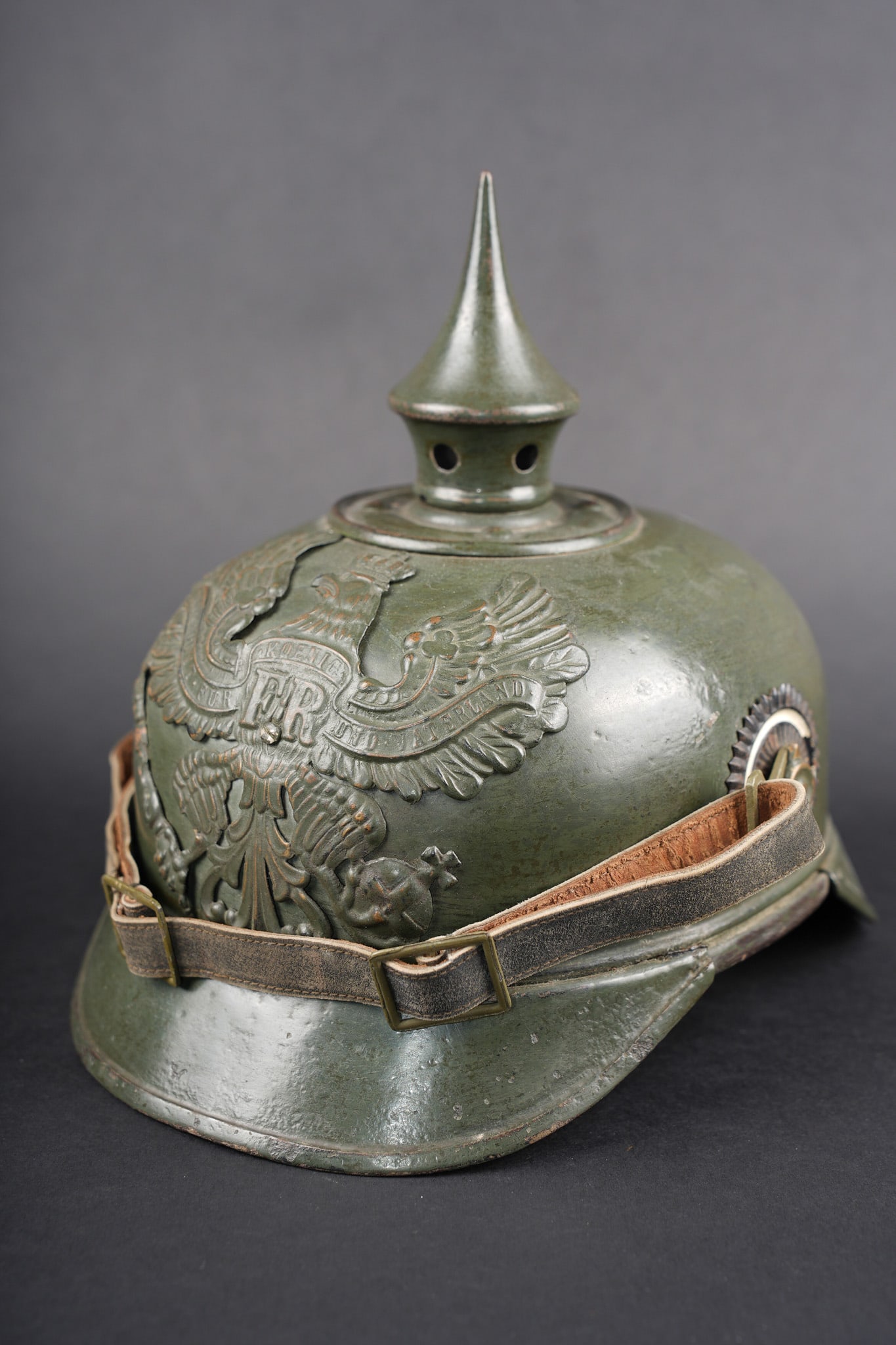 Casque a pointe prussien ersatz en tole feldgrau fabricant Weissenburger. Prussian ersatz: Casque a pointe prussien ersatz en tole feldgrau fabricant Weissenburger. Casque du fabricant Weissenburger de Cannstadt, en tole d acier. Plaque a l aigle prussien, modele specifique a ce type de cas