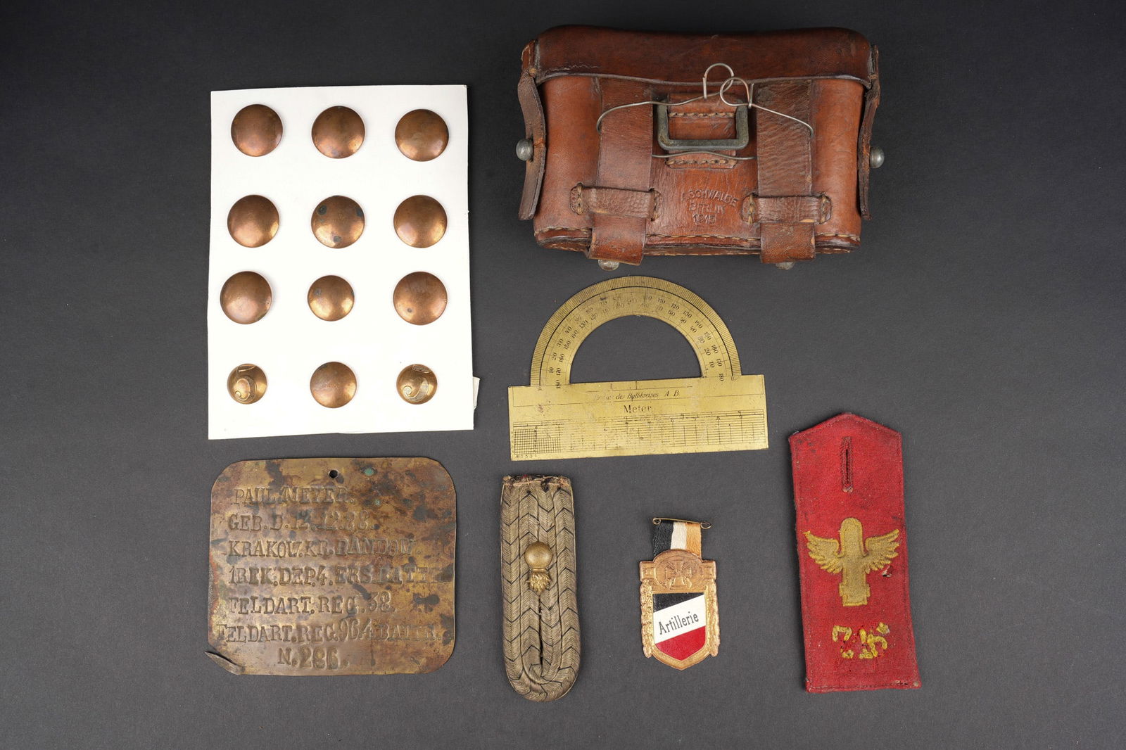 Lot d equipements, insignes d artilleur allemand. Lot of German artillery equipment and insignia: Lot d equipements, insignes d artilleur allemand. Une cartouchiere pour troupes technique, en cuir fauve, datee 1915, une des pattes a une petite dechirure au niveau de l œillet. Une patte d epaule M