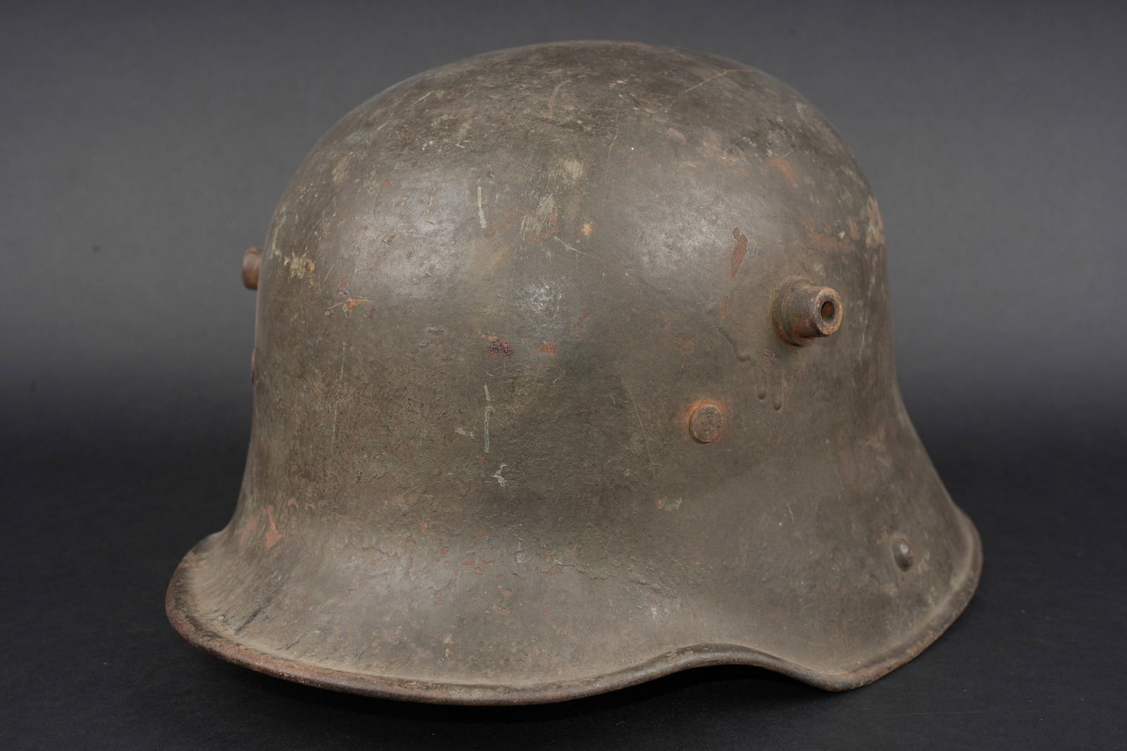 Belle coque de casque allemand Stahlhelm M1916 feldgrau. Fine shell of a German feldgrau Stahlhelm: Belle coque de casque allemand Stahlhelm M1916 feldgrau. Coque avec plus de 90% de sa peinture Feldgrau sur l exterieur. Marquage tres leger, difficile a dechiffrer, sauf erreur K64. Avec un bandeau d