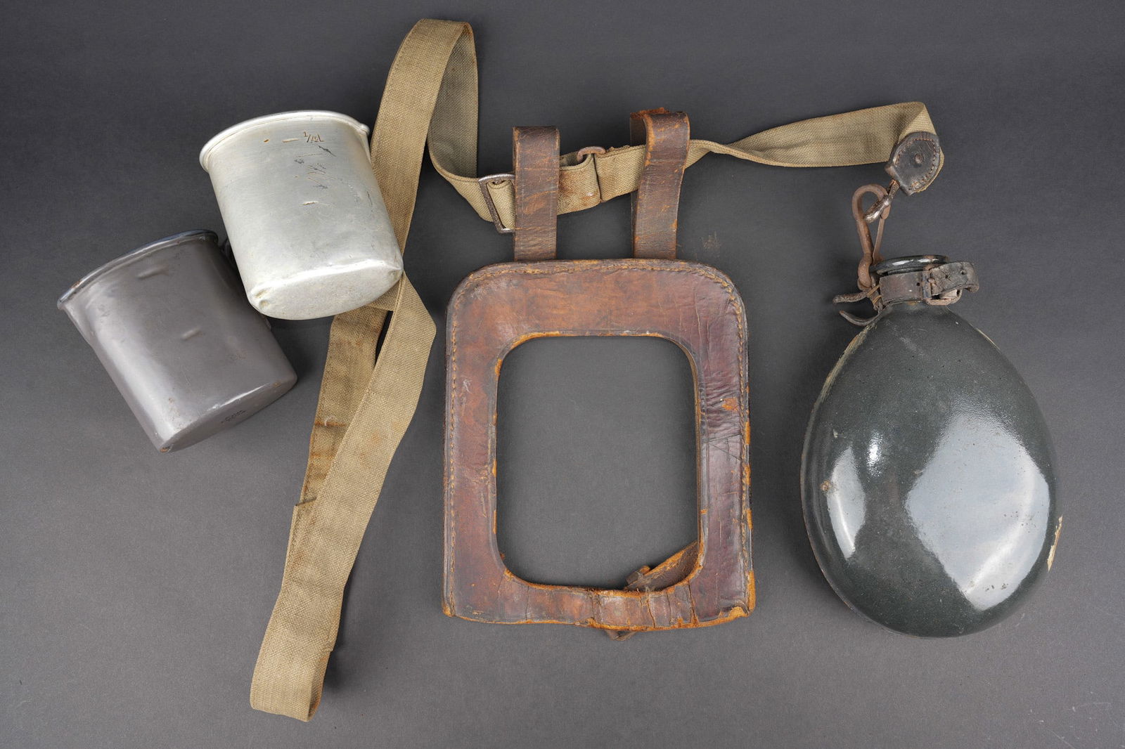 Lot d equipements individuels allemands.: Lot d equipements individuels allemands. Un bidon emaille feldgrau avec son crochet, un quart emaille FCB Fulda 1916, un quart aluminium du fabricant Schmidt de Wurzen date 1910, deforme, un porte pel