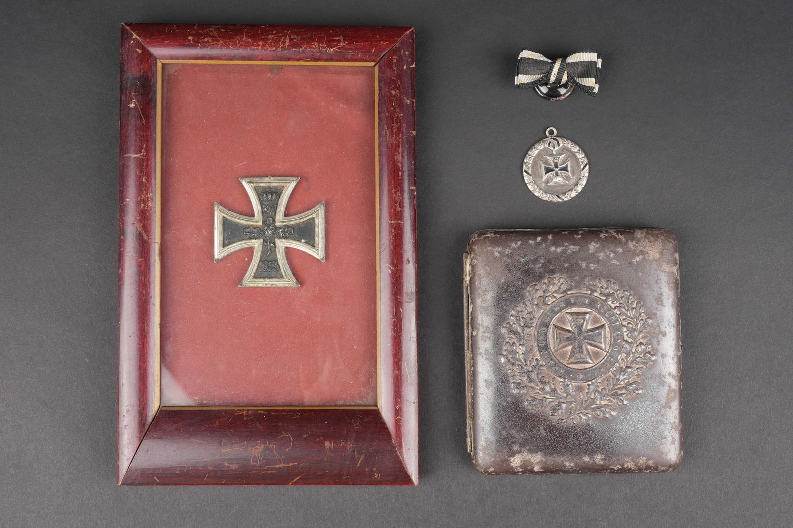 Lot d objets relatifs a la Croix de Fer. Lot of items related to the Iron Cross.: Lot d objets relatifs a la Croix de Fer. Une croix de fer de 2nde classe dont l anneau a ete retire, encadree. Un etui a cigarettes a motif de croix de fer, un pendentif et un rappel de boutonniere. U
