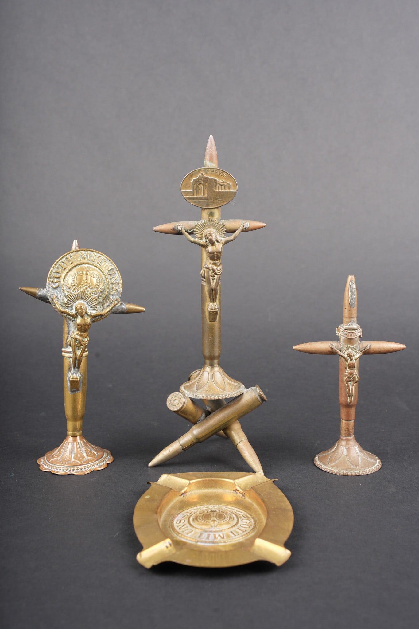 Ensemble de 3 crucifix et un cendrier artisanat de tranchee. Set of three crucifixes and one: Ensemble de 3 crucifix et un cendrier artisanat de tranchee. 3 crucifix dont un avec un medaillon YPRES, un autre avec une banderole YPRES, un troisieme crucifix et un cendrier avec chacun un macaron