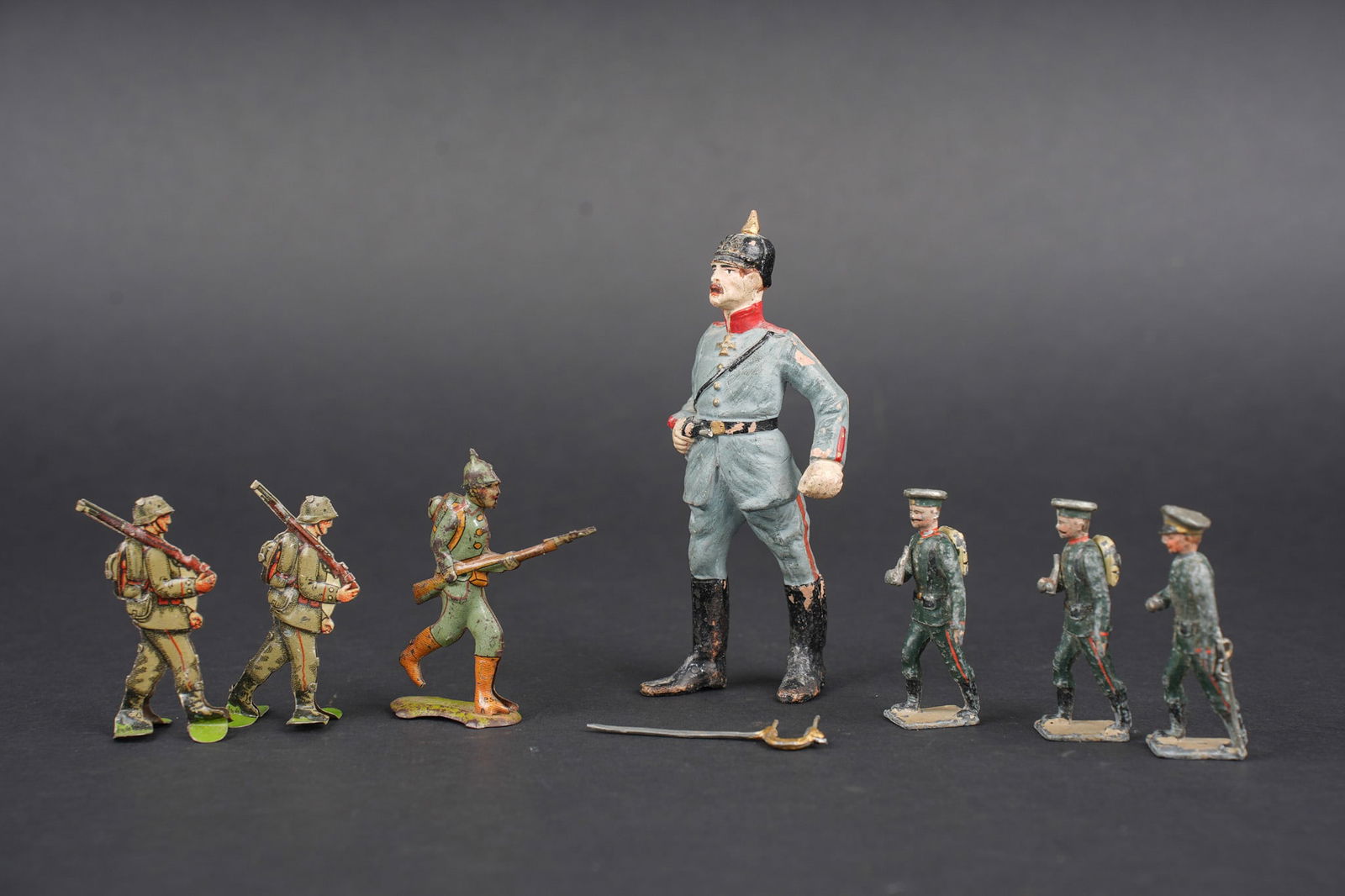 Ensemble de figurines de soldats allemands. Set of German soldier figurines.: Ensemble de figurines de soldats allemands. Un grand officier d environ 11cm de haut, 3 metalliques coiffes de Mutze, 3 en fer blanc plates. Usure d usage. Set of German soldier figurines including
