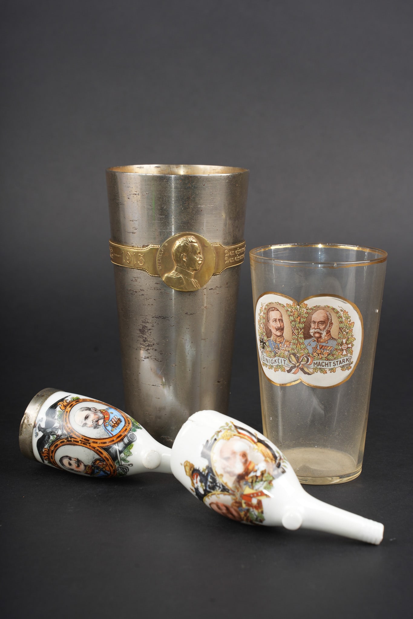 Un verre, une timbale et 2 pipes aux effigies des Kaiser allemand et autrichien. A glass, a beaker,: Un verre, une timbale et 2 pipes aux effigies des Kaiser allemand et autrichien. Aux effigies de Wilhelm II et Franz Joseph I , un verre fin, un petit defaut au col, usure d usage. Un Kriegs Becher 19