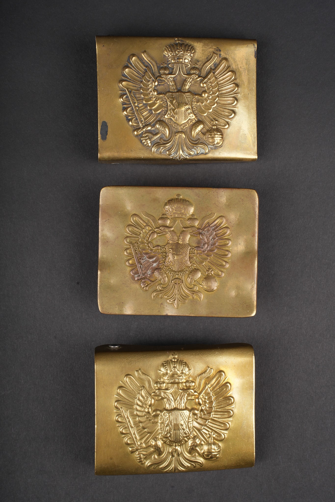 Autriche-Hongrie lot de 3 boucles de ceinturon. Austria-Hungary lot of three belt buckles.: Autriche-Hongrie lot de 3 boucles de ceinturon. 3 boucles laiton a l aigle bicephale. Une a crochet et pontet, d epoque, et deux a systeme d ardillons, authenticite non garantie. Usure d usage. Group