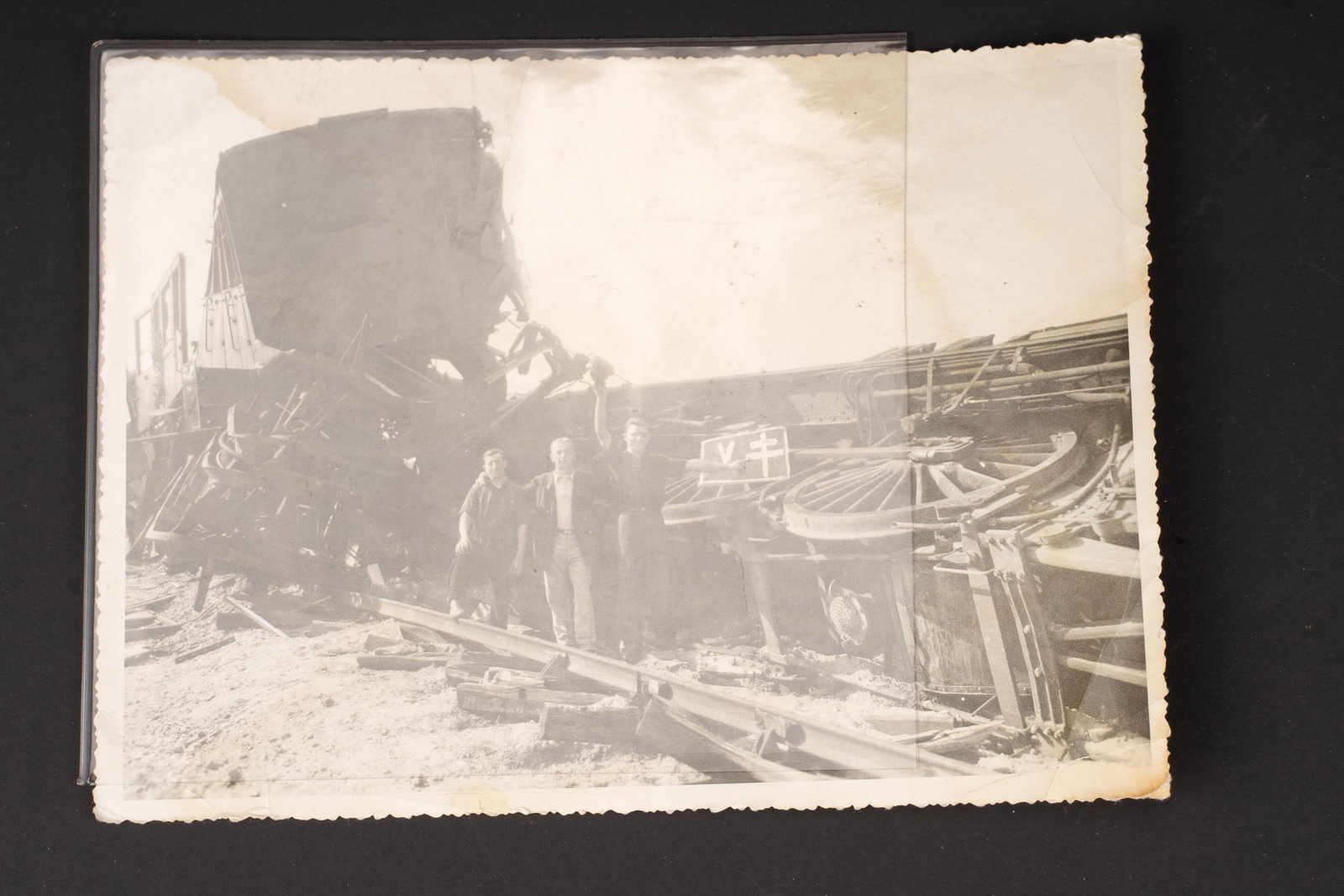 Photo de FFI. FFI Press photograph.: Photo de FFI. En noir et blanc. 12,5 x 16,5 cm. Representant un train qui a deraille suite a un sabotage des voies ferrees. Trois resistant poses fierement devant la carcasse du train en brandissant u