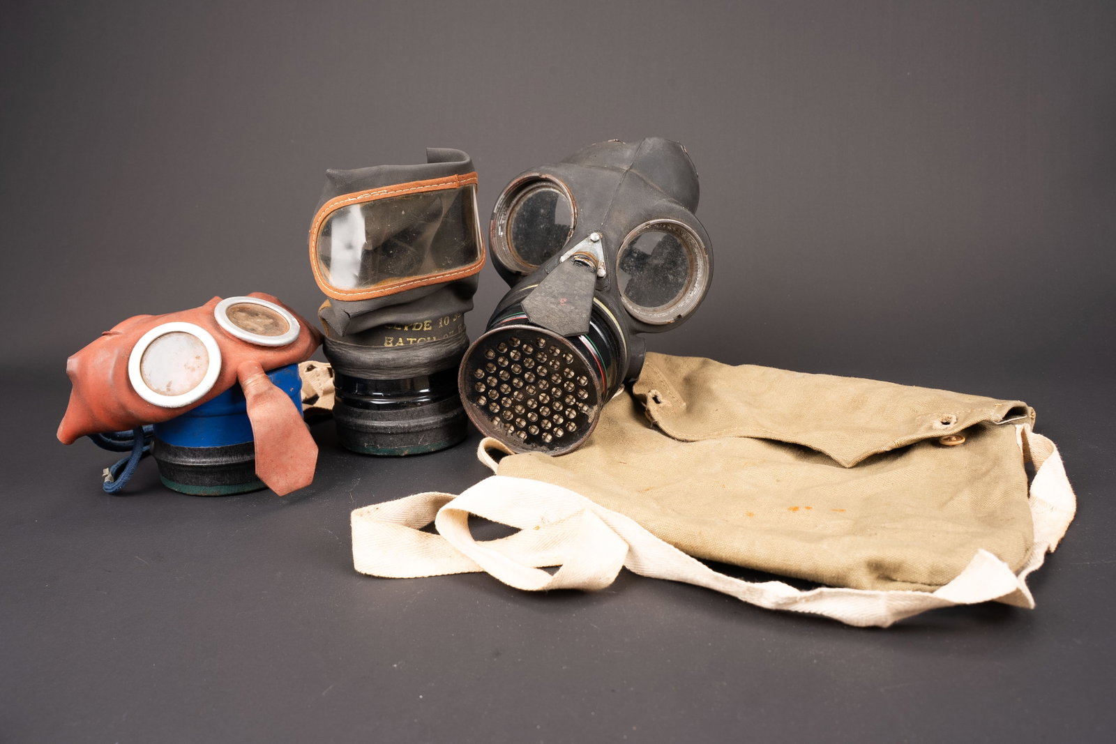 Masque anti-gaz civil britannique. British civilian gas mask.: Masques anti-gaz civil britannique. Comprenant un masque en caoutchouc rouge, filtre bleu, toutes les sangles sont presentes, modele pour enfant. Date avril 1940. Un masque anti-gaz en caoutchouc