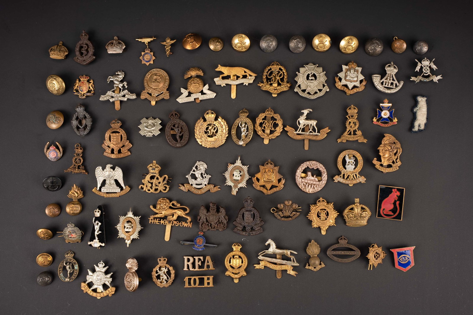 Cap badge britannique. British cap badge.: Cap badge britannique. Comprenant 49 cap badge en metal. 8 cap badge en plastique. 16 boutons metalliques. Certaines attaches sont manquantes. A noter une certaine usure et patine des pieces. Etat