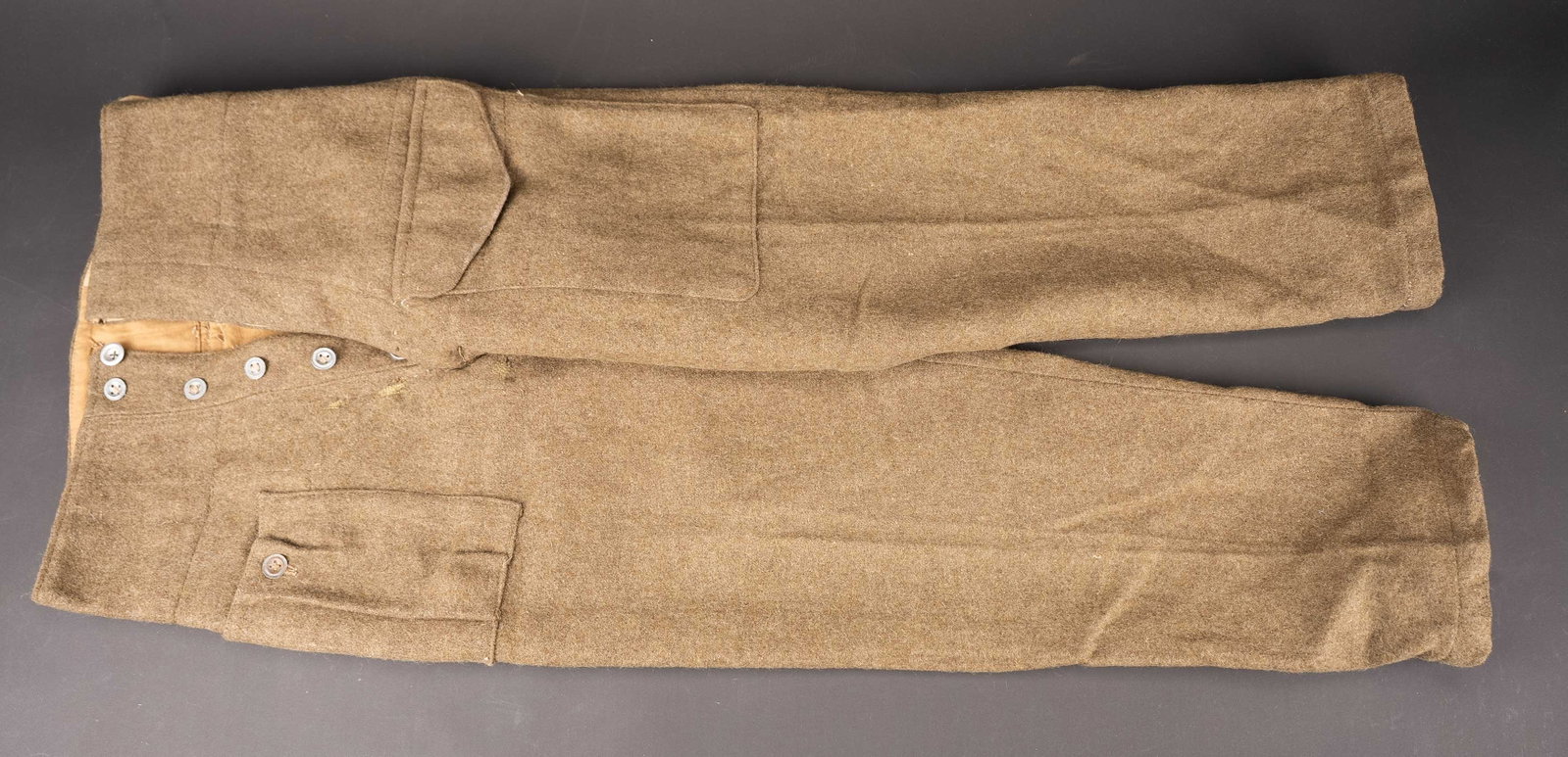 Pantalon de Battle Dress. British battle dress trousers.: Pantalon de Battle Dress. En laine de serge marron. Tous els boutons sont presents, mais de modeles differents. Interieur double en tissu coton beige. Marquages au tampon WD O138. La lettre O correspo