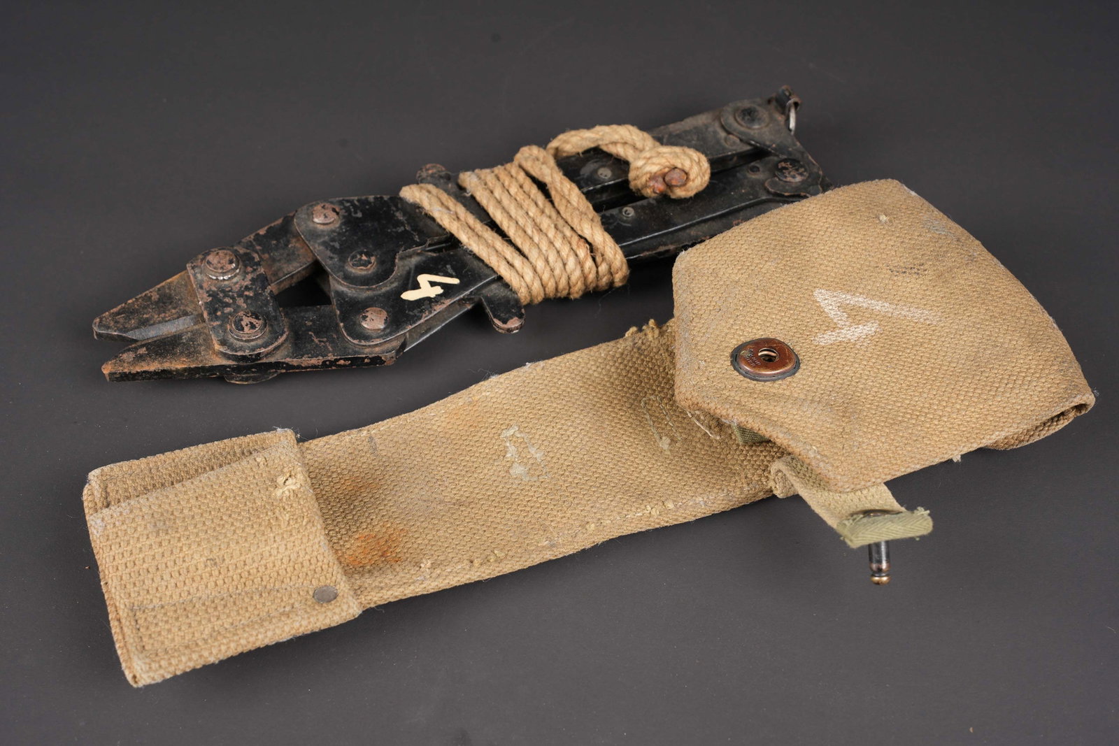 Pince coupante britannique. British wire cutter.: Pince coupante britannique. Housse en forte toile web. Le bouton pression est fonctionnel. Chiffre 4 peint en blanc sur le rabat. Les passants arrieres sont presents. Fabrication MECO 1917 avec broad 