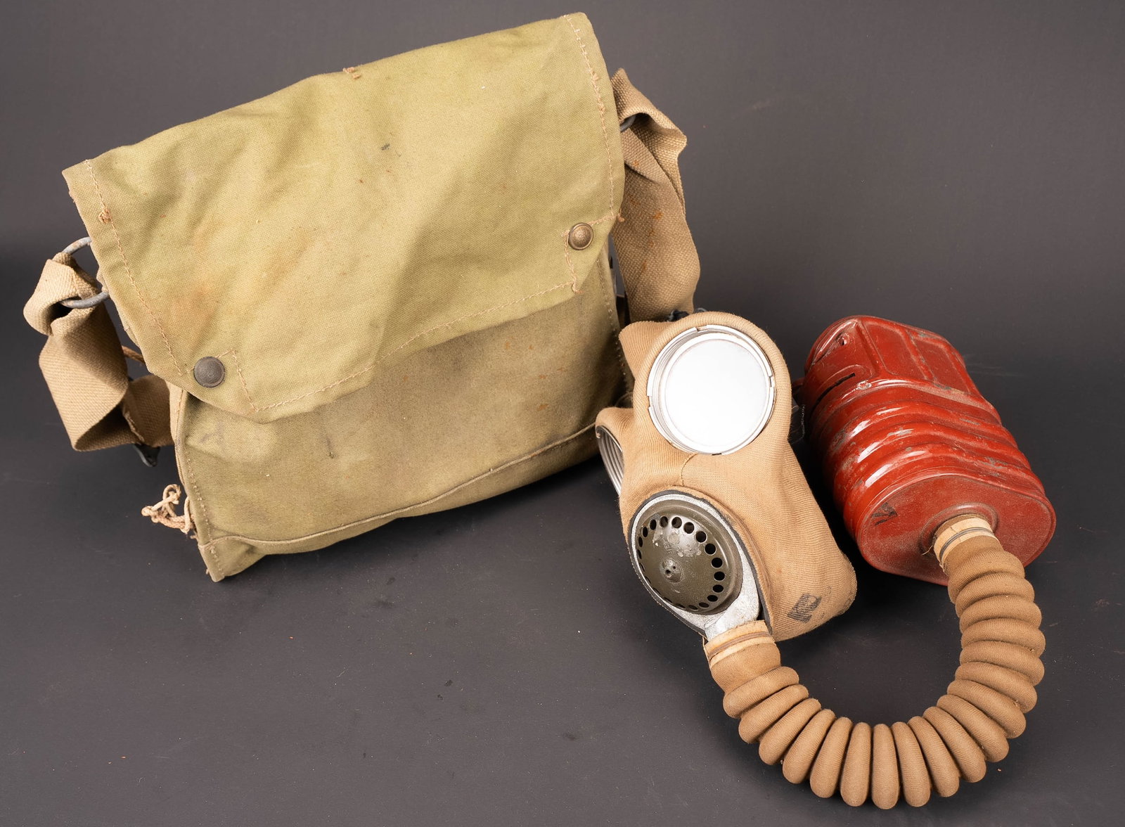 Masque anti-gaz britannique. British gas mask: Masque anti-gaz britannique. Housse en toile kaki, les boutons pressions sont fonctionnels. Sangle de transport complete, ainsi que toutes les cordelettes. Marquages sous le rabat Mark XII, date 1940.