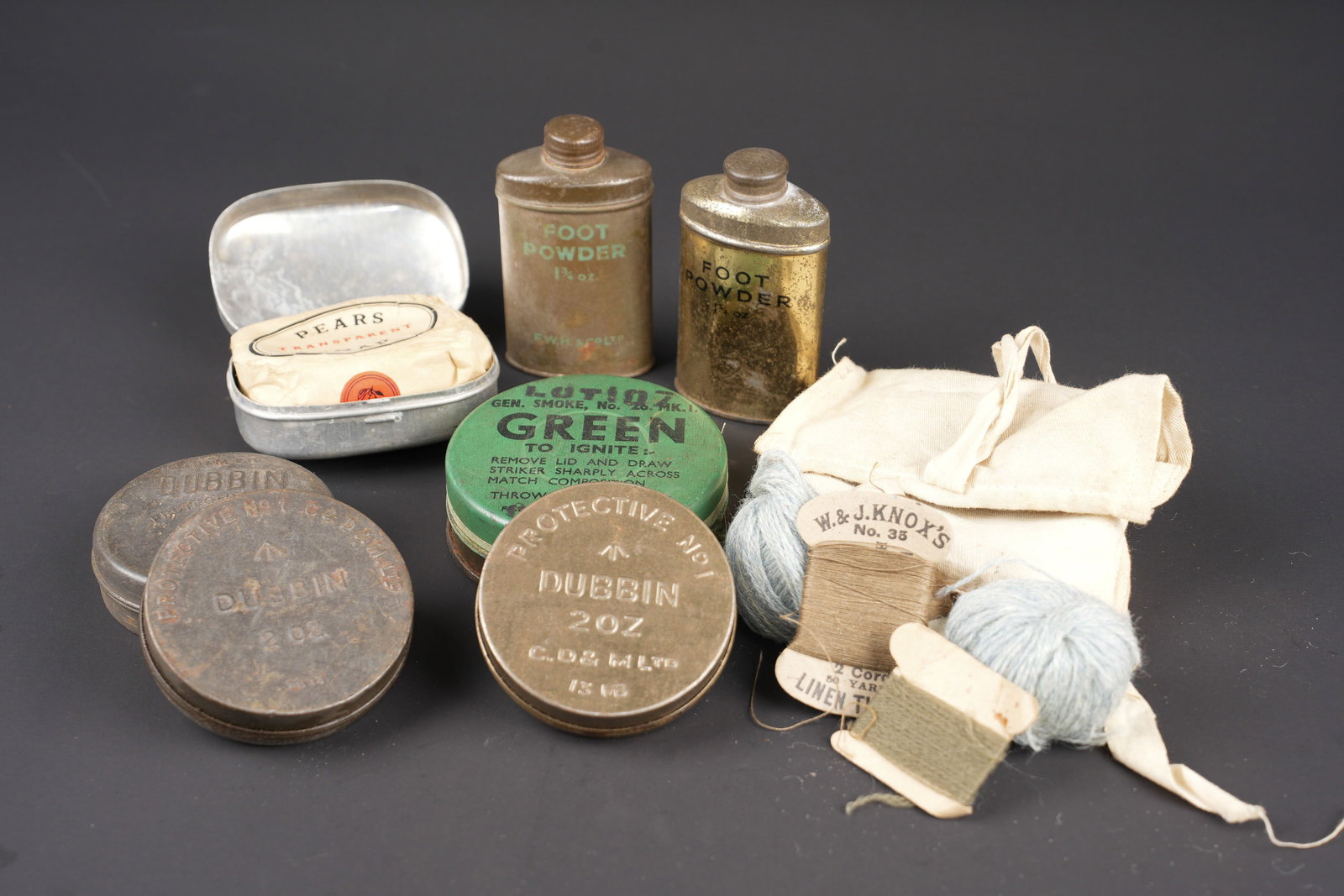 Accessoires de toilette britannique. British toiletry accessories: Accessoires de toilette britannique. Comprenant deux modeles differents de flacons Foot Powder, complets. Quelques bosses visibles. Trois boites en metal completes, marquee Dubbin Protectiv. Un savon