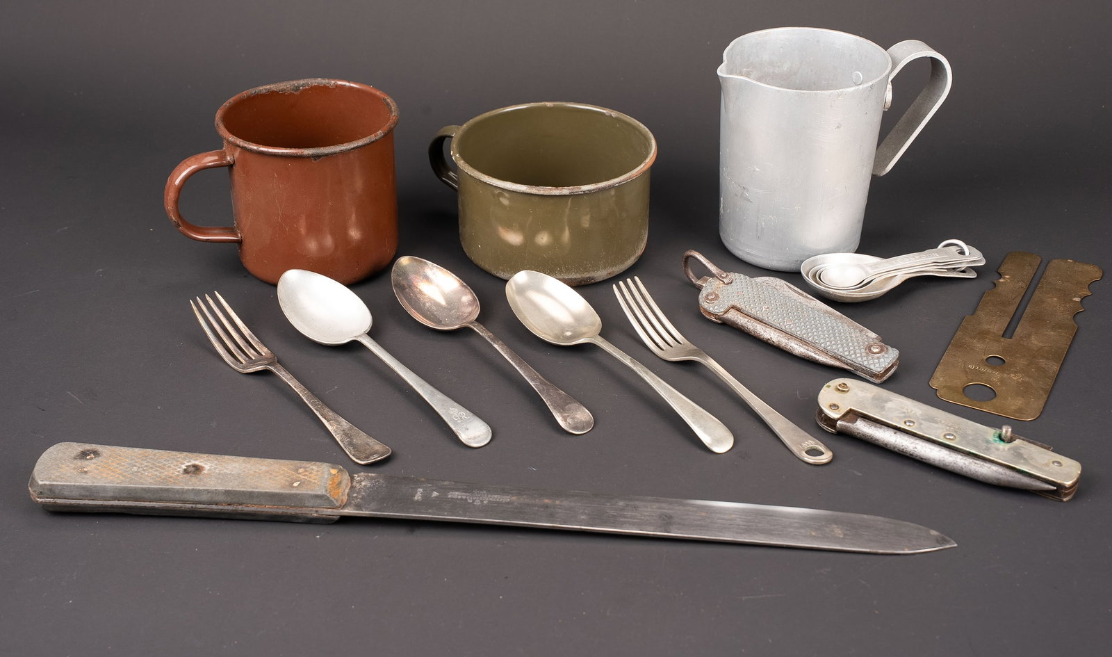 Accessoires de cuisine britannique. British cooking accessories: Accessoires de cuisine britannique. Comprenant une grande cuillere en metal, datee 1942. Une fourchette en metal argente de la RAF, datee 1941. Une grande cuillere avec monogramme sous couronne. Une