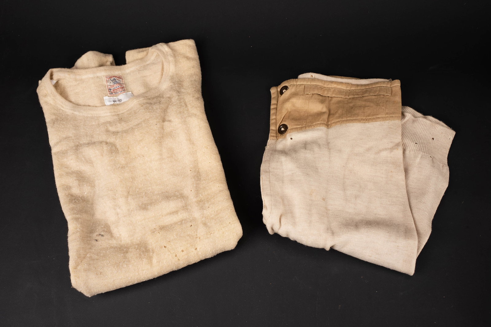 Sous-vetement britannique. British underwear.: Sous-vetement britannique. Comprenant un maillot de corps en tissu laineux blanc. Manches courtes. Etiquette dans le col marquee Sheperd M-3 1944. Un calecon mi long en drap epais tissu coton blanc, l