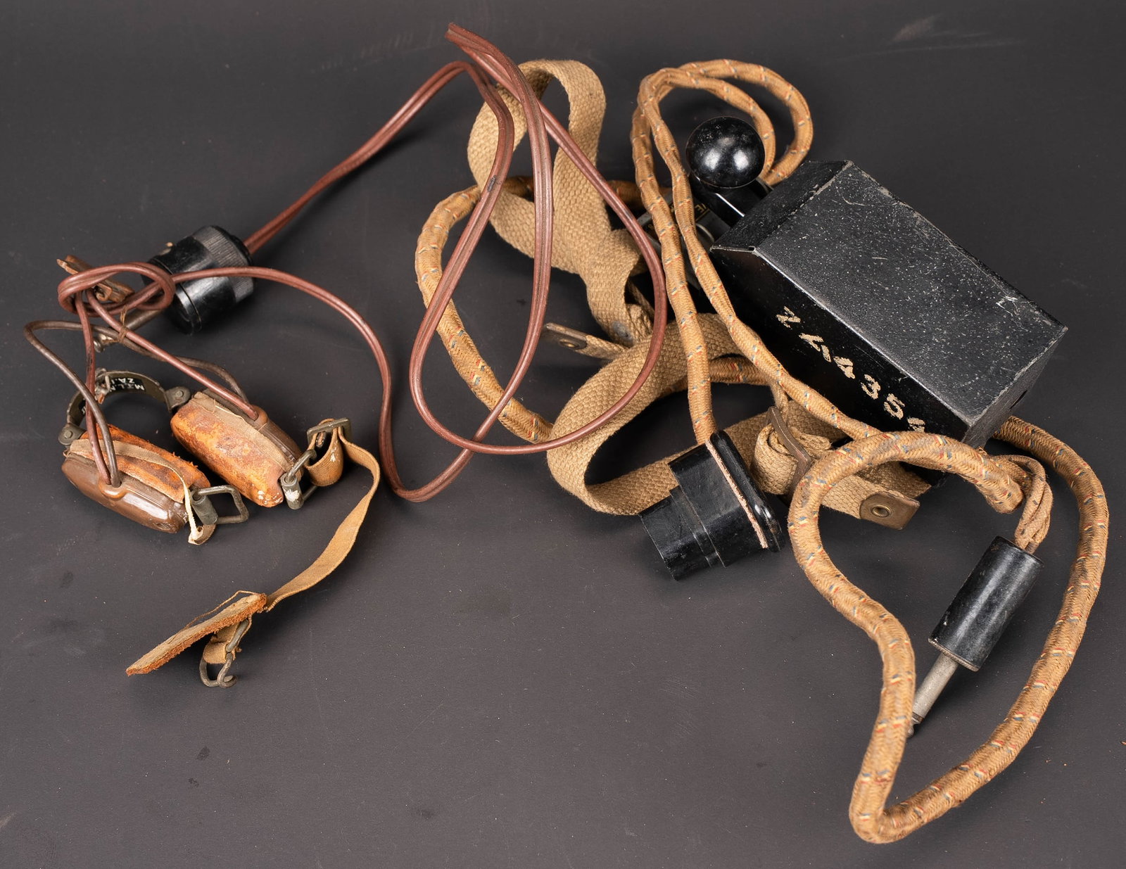 Accessoires radio britannique. British radio accessories.: Accessoires radio britannique. Comprenant un laryngophone complet, elastique en bon etat. Cable et prise presents. Les marquages sont illisibles. Un boitier morse de cuisse, fonctionnel, marque Receiv