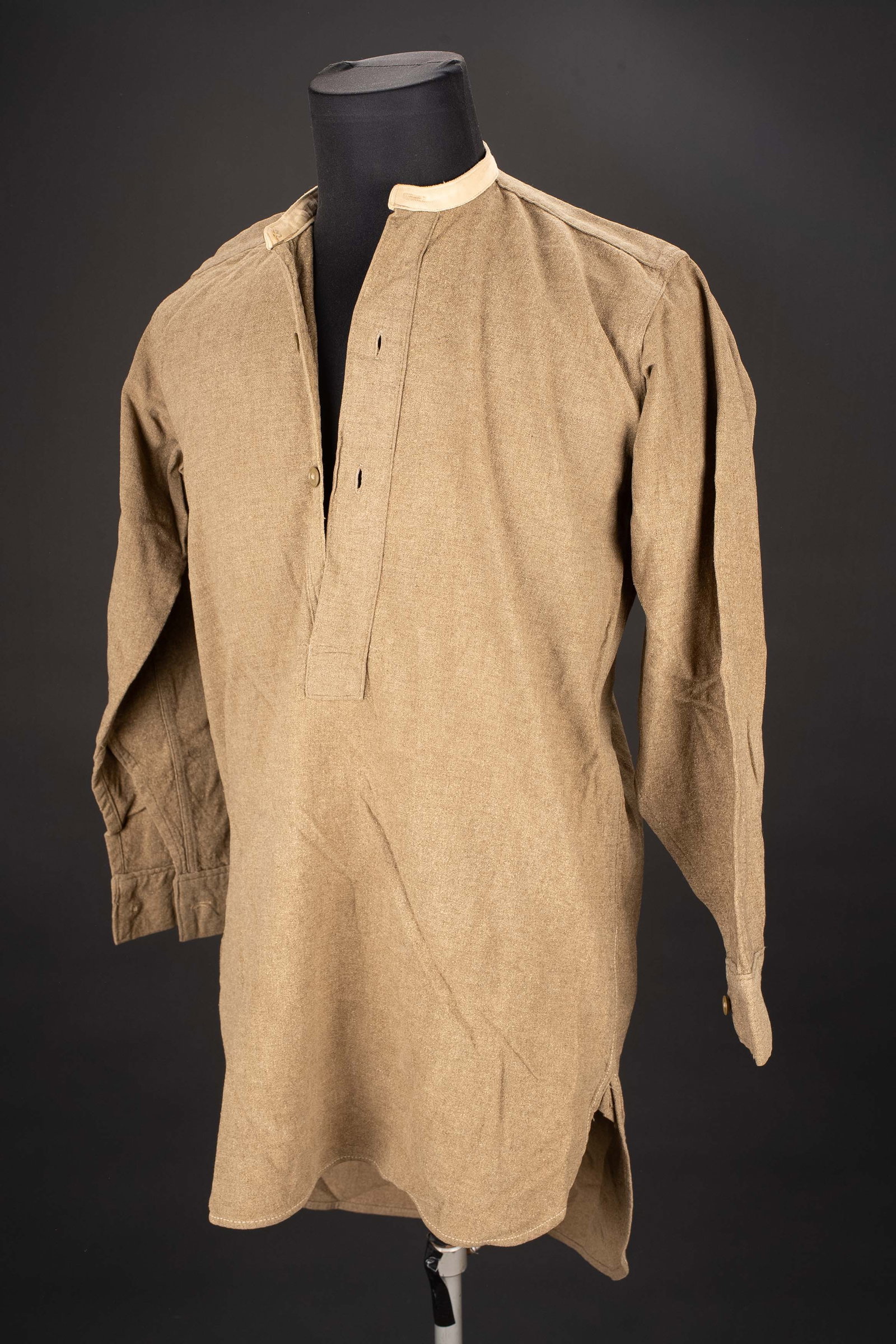 Chemise britannique. British shirt.: Chemise britannique. En epais drap kaki. Col en tissu beige. Tous les boutons sont presents. Marquages Fctory Belfast, sans date visible. A noter une legere usure et patine de la piece. Etat I-. Briti
