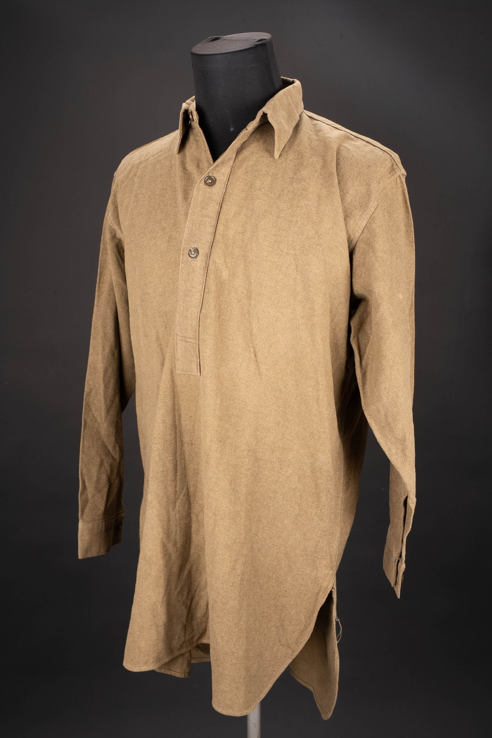 Chemise britannique. British shirt: Chemise britannique. En epais drap de laine kaki. Tous ls boutons sont presents. Marquages fabricant Belfast 1945, et indication de taille 8. A noter une legere usure et patine de la piece. Etat I-. B