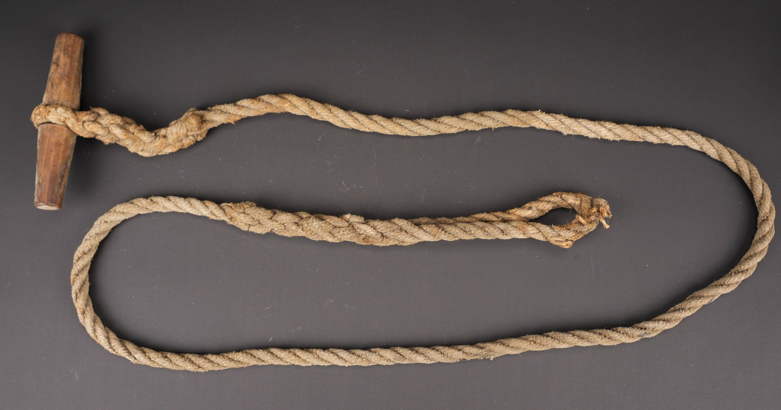 Toggle Rope. Toggle Rope: Toggle Rope. Corde complete mais fortement usee. Poignee en bois complete. Sans marquages visibles. A noter une certaine usure et patine de la piece. Etat II+. Toggle rope. Complete rope with wooden h