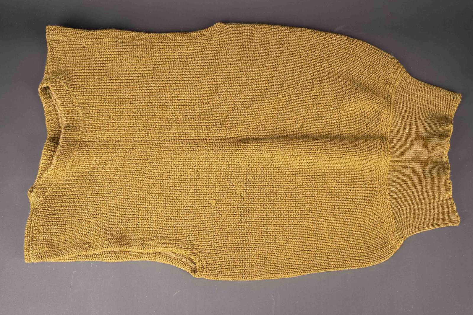 Pull sans manche US. US sleeveless sweater: Pull sans manche US. En epaisse laine OD. Modele sans manches. Sans marquages visibles. A noter une legere usure et patine de la piece, ainsi que quelques traces de mite. Etat II+. US sleeveless