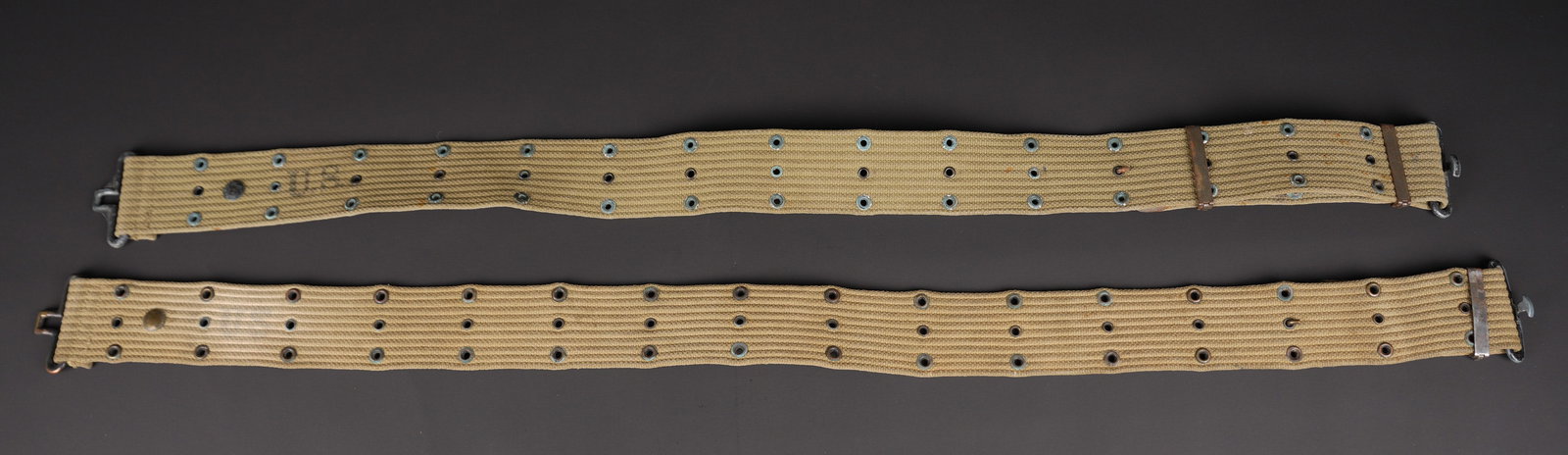 Ceinturons M-36. US M 36 Belt.: Ceinturon M-36. Deux ceinturons en forte toile OD3. Boucleries en metal et laiton. Restes de marquages US visibles. Fabrications illisibles. A noter une certaine usure et patine des pieces. Etat II+. 