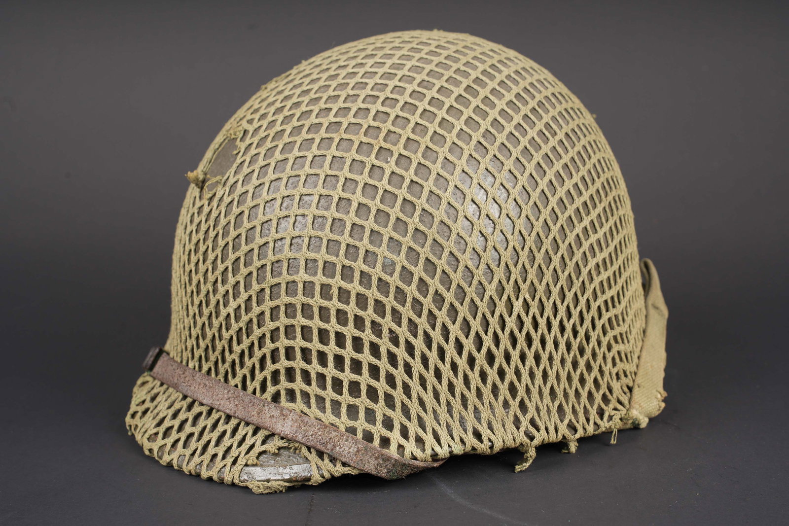 Casque USM1. US M1 Helmet.: Casque USM1. Coque de casque USM1. Fermeture du jonc a lavant. Coque completement repeinte, couvrant dimportantes traces doxydation. Pontets fixes. Les jugulaires sont presentes mais recousues, vraise